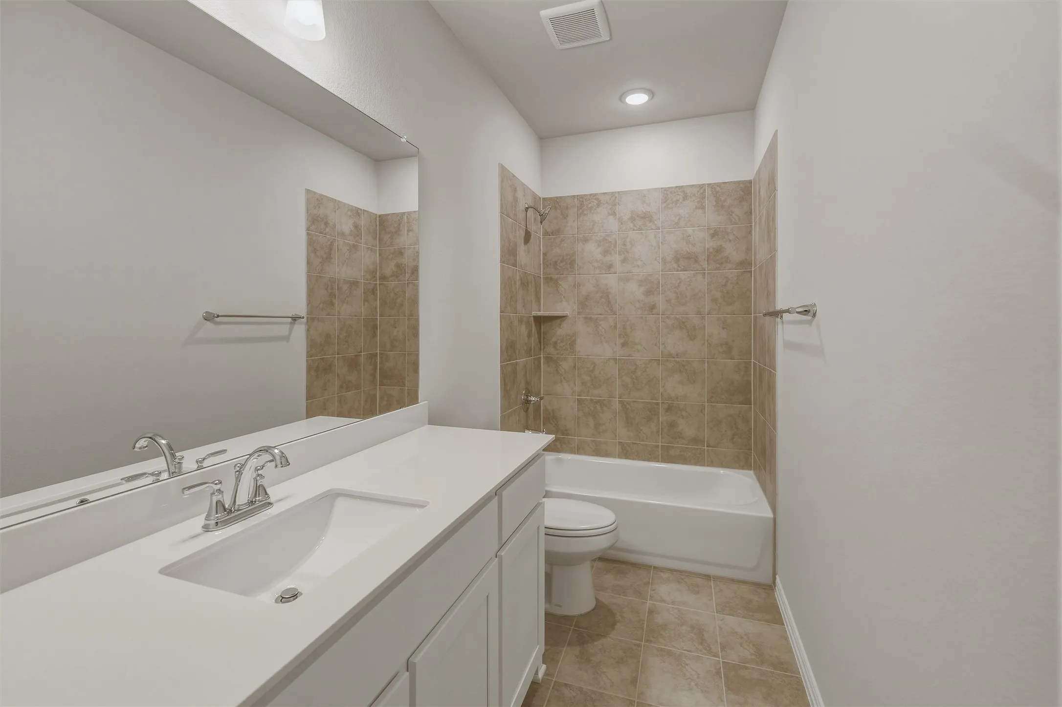 Bathroom featuring a white vanity with an integrated sink, chrome faucet, and expansive mirror