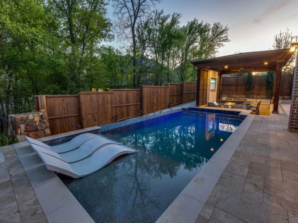 Rectangular pool with integrated lounging area and light-colored coping