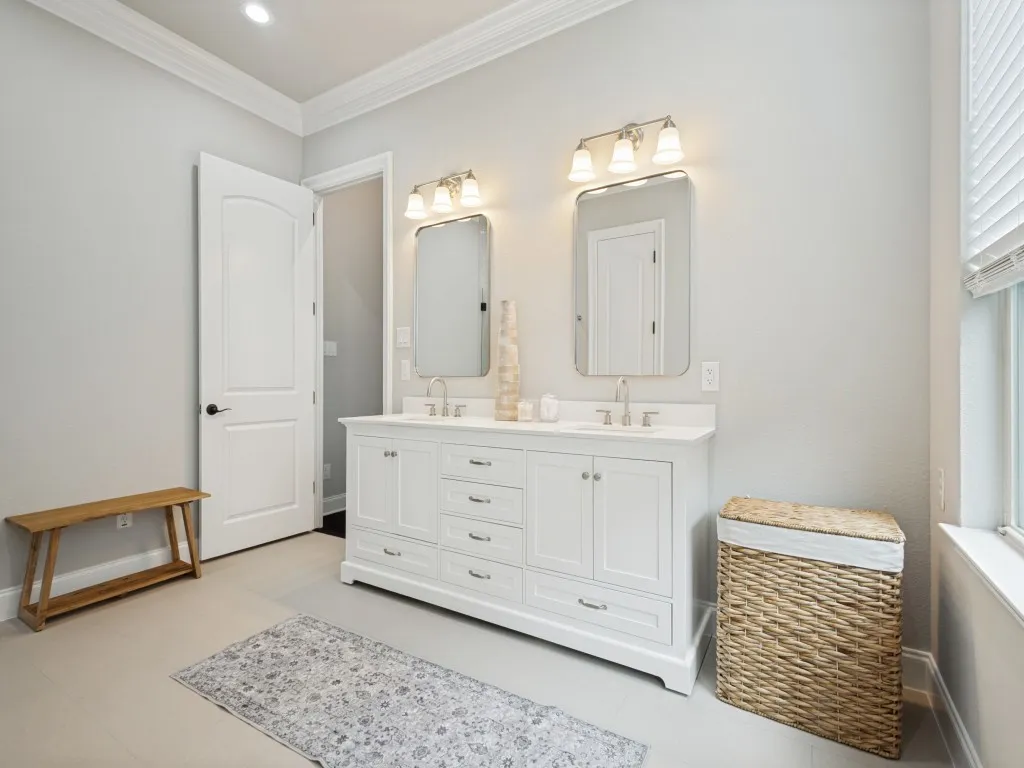 Dual vanity with white cabinetry and integrated sinks, brushed nickel fixtures, and individual rectangular mirrors