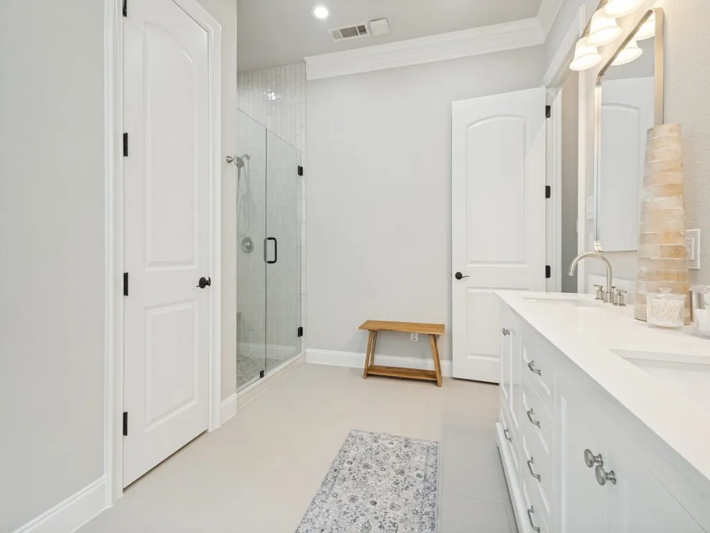 Bathroom featuring a double vanity with white cabinetry, quartz countertops, and dual undermount sinks