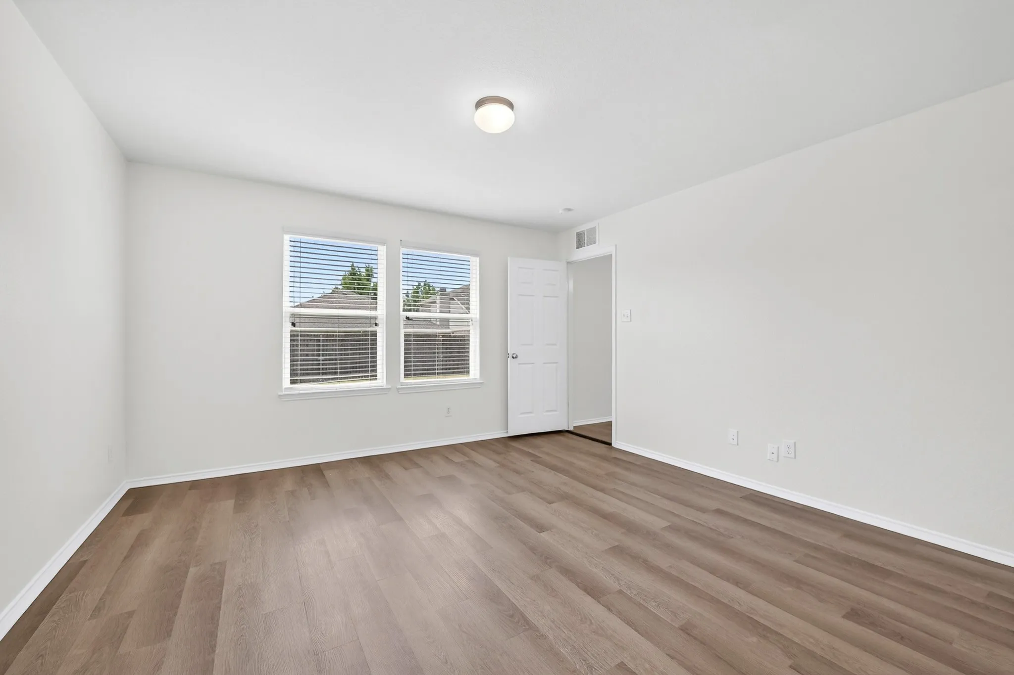 Large primary bedroom located in the rear of the home with LVP flooring and freshly painted walls
