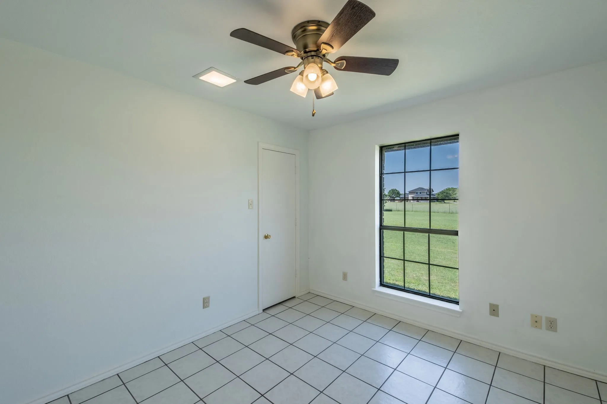Guest Bedroom 3 with natural lighting and ceiling fan.