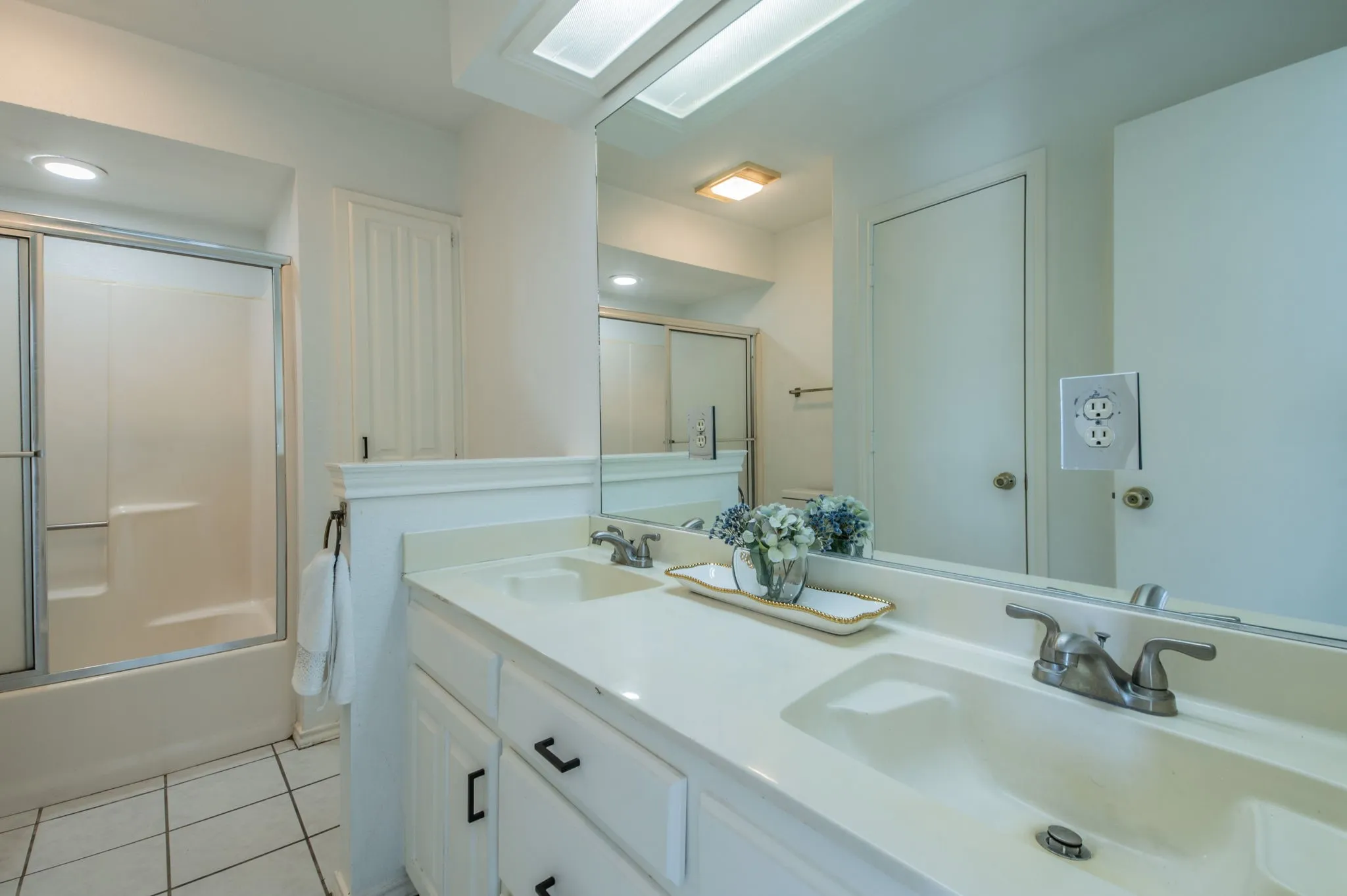 Guest bathroom with dual sinks and tub/shower combo.