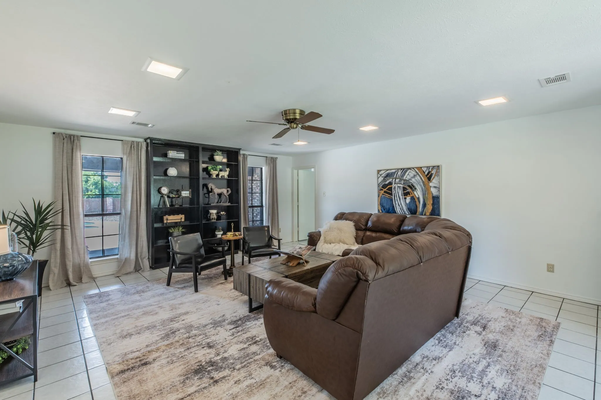 Living room with natural light and ceiling fan.