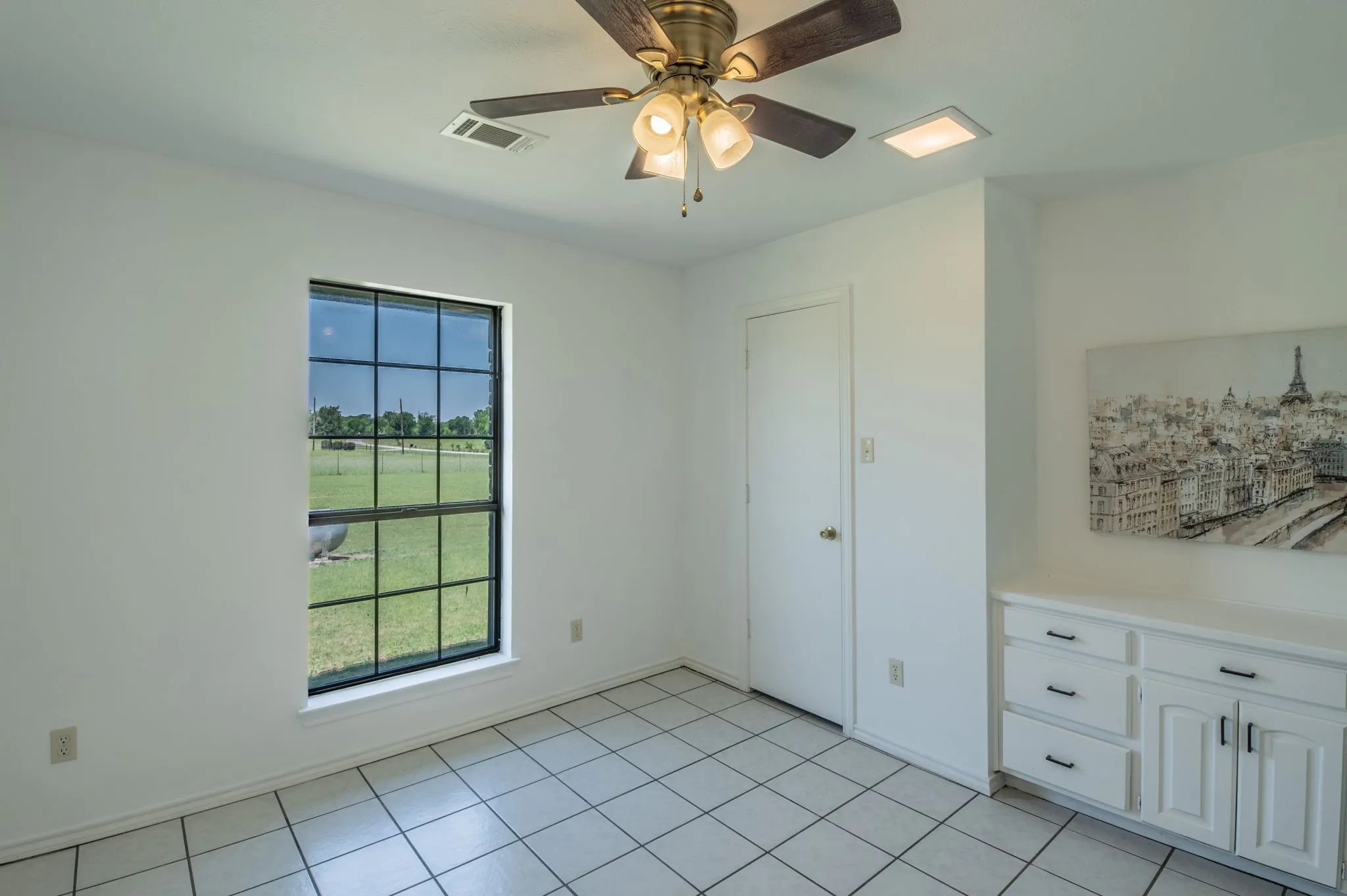 Guest Bedroom 2 with built-in desk and natural lighting.