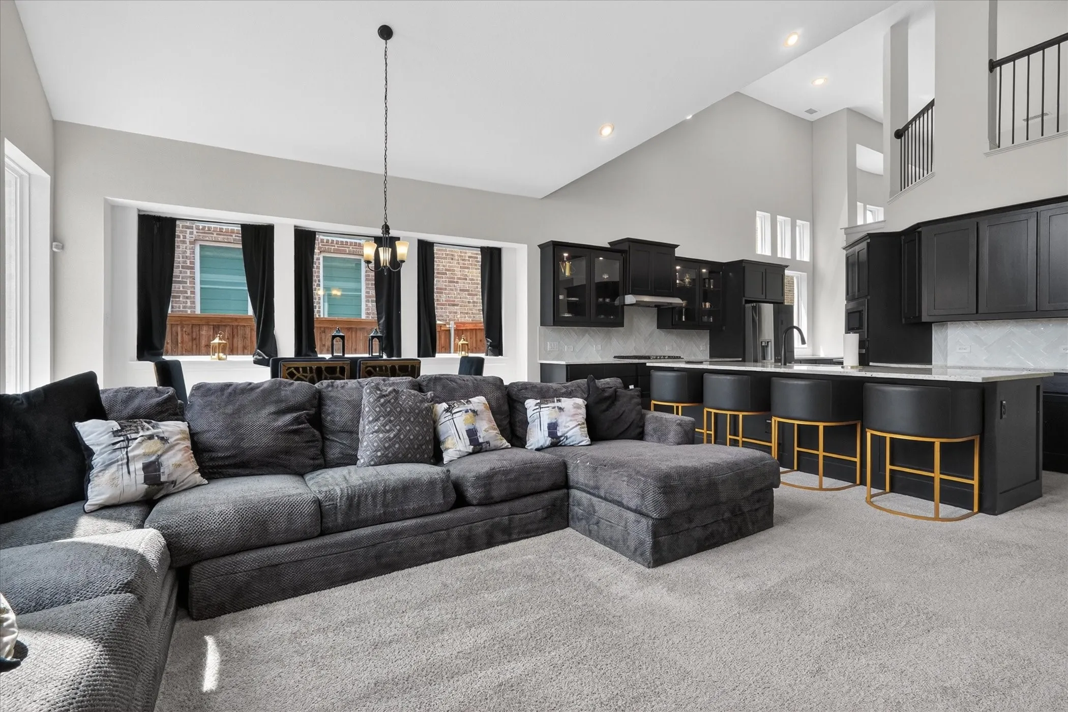 Open-concept living space featuring a two-story ceiling, recessed lighting, and large windows