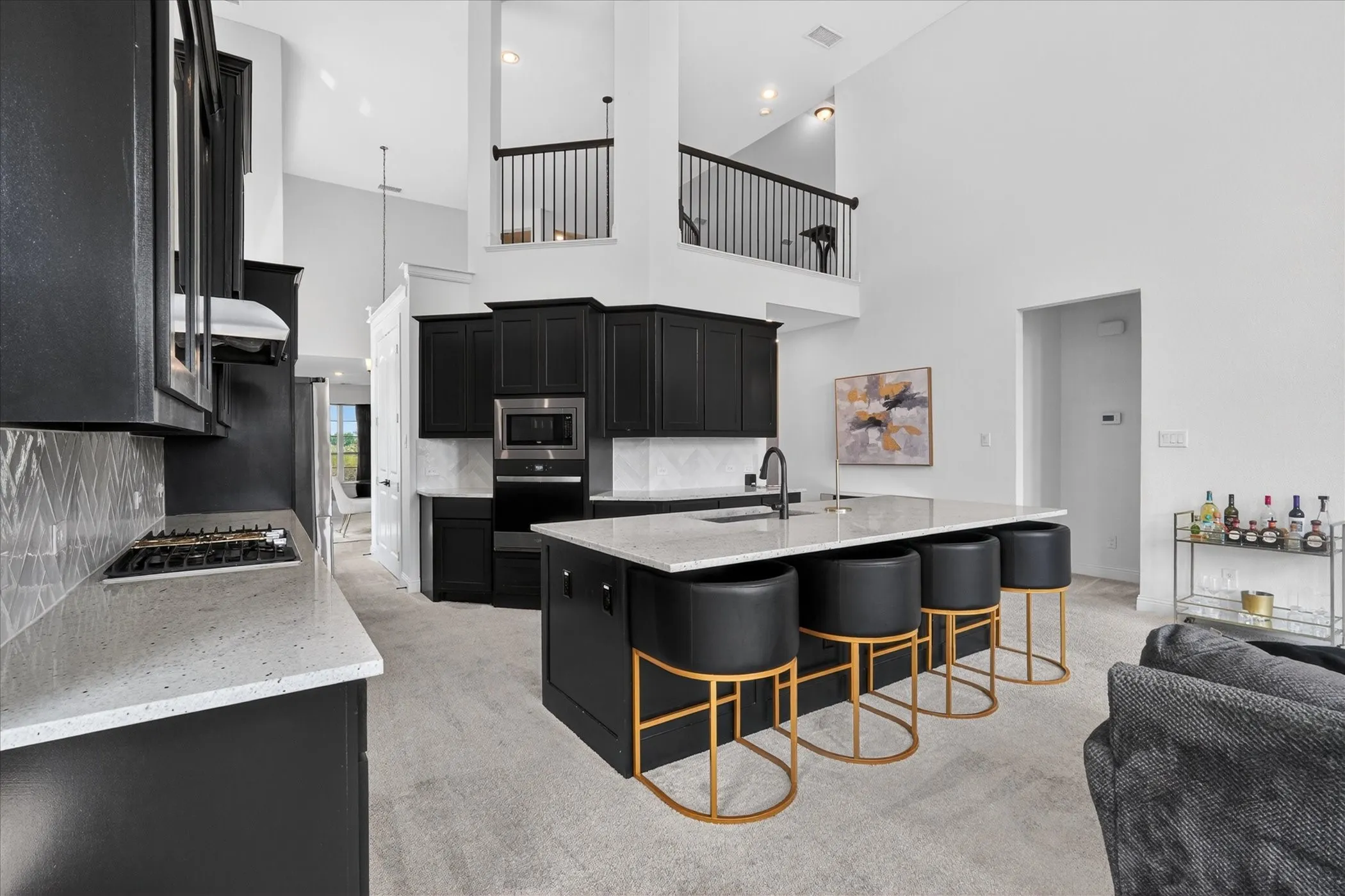 Kitchen featuring dark cabinetry, light countertops, integrated appliances, and a central island with bar seating