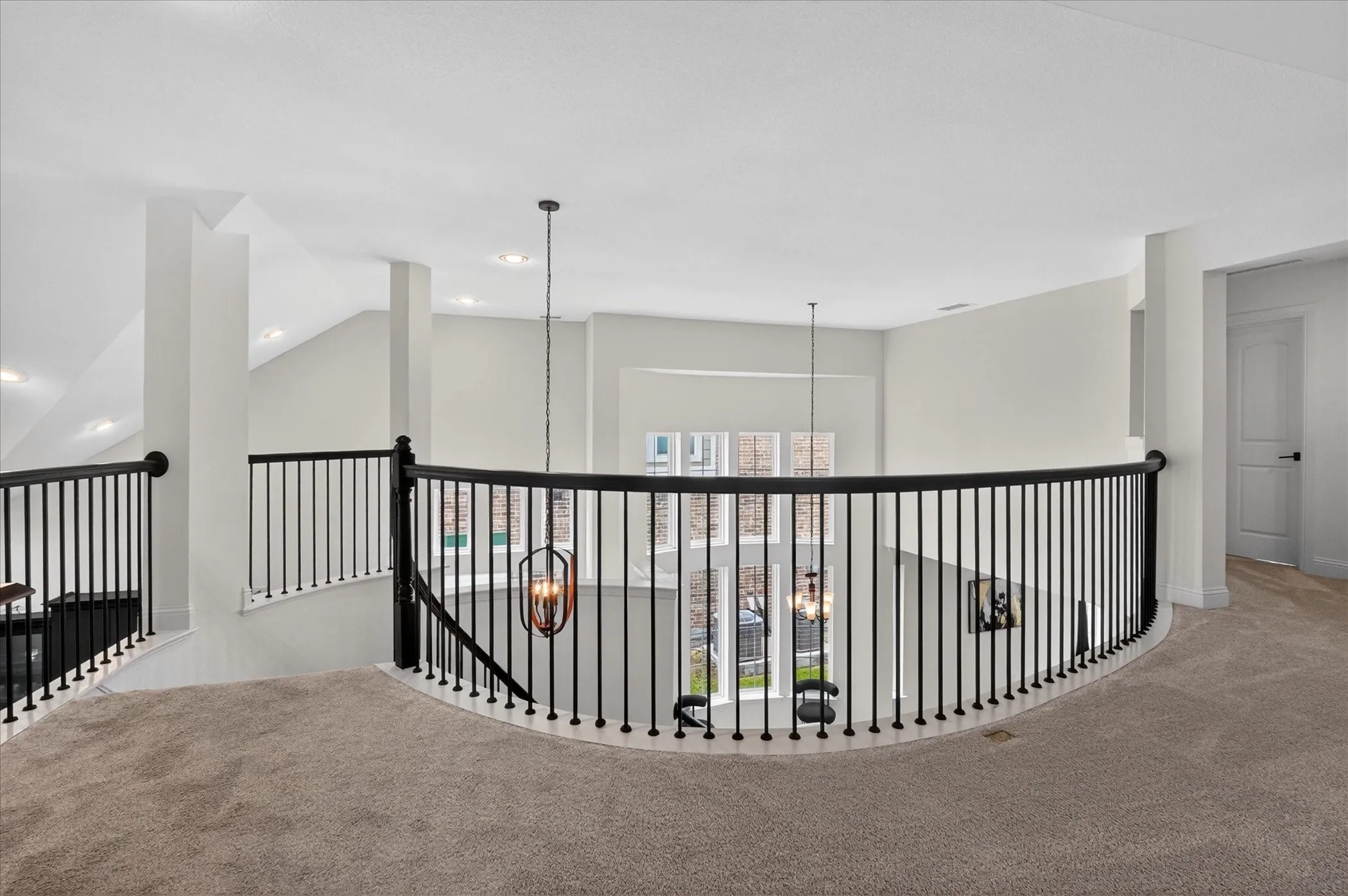 Upper-level landing with curved black iron balustrade