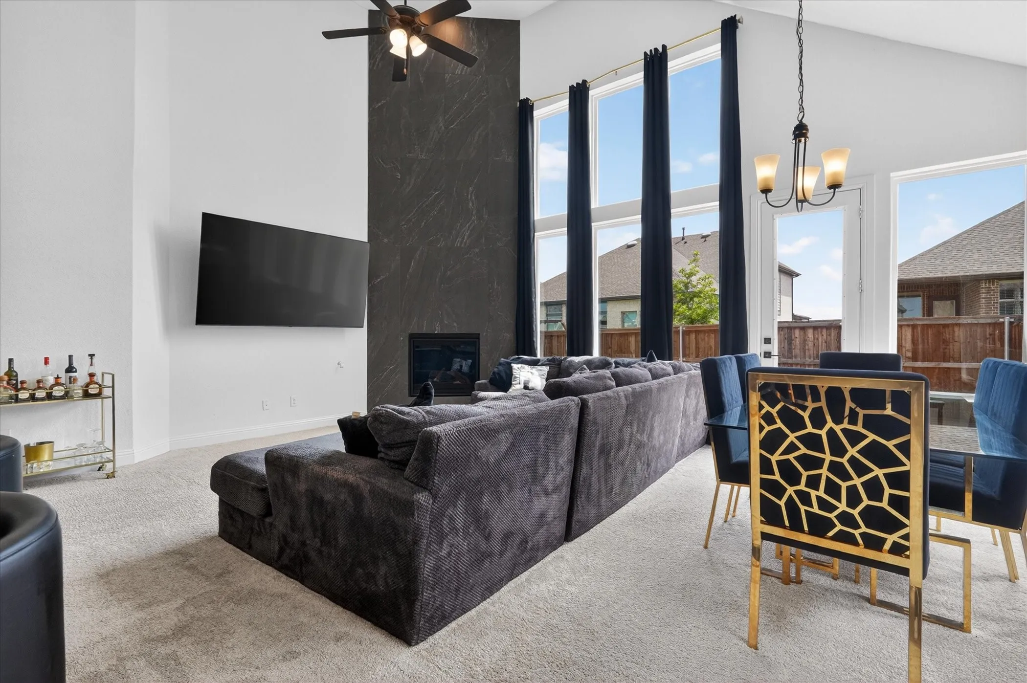 Spacious open-concept living area featuring a vaulted ceiling and a floor-to-ceiling accent wall with a built-in electric fireplace
