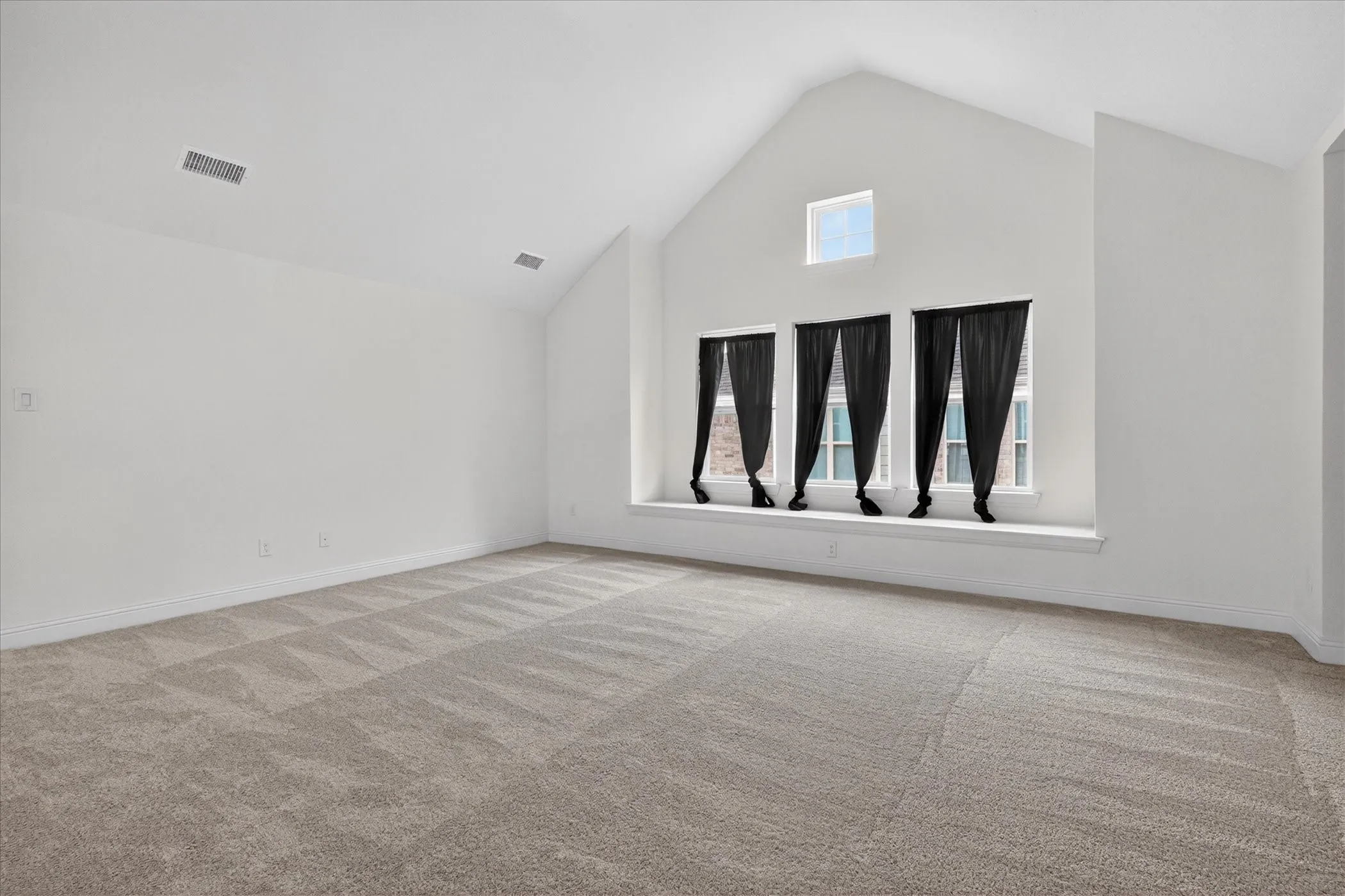 Oversized Game room featuring vaulted ceilings, light neutral carpeting, a large window seat, and multiple windows providing natural light