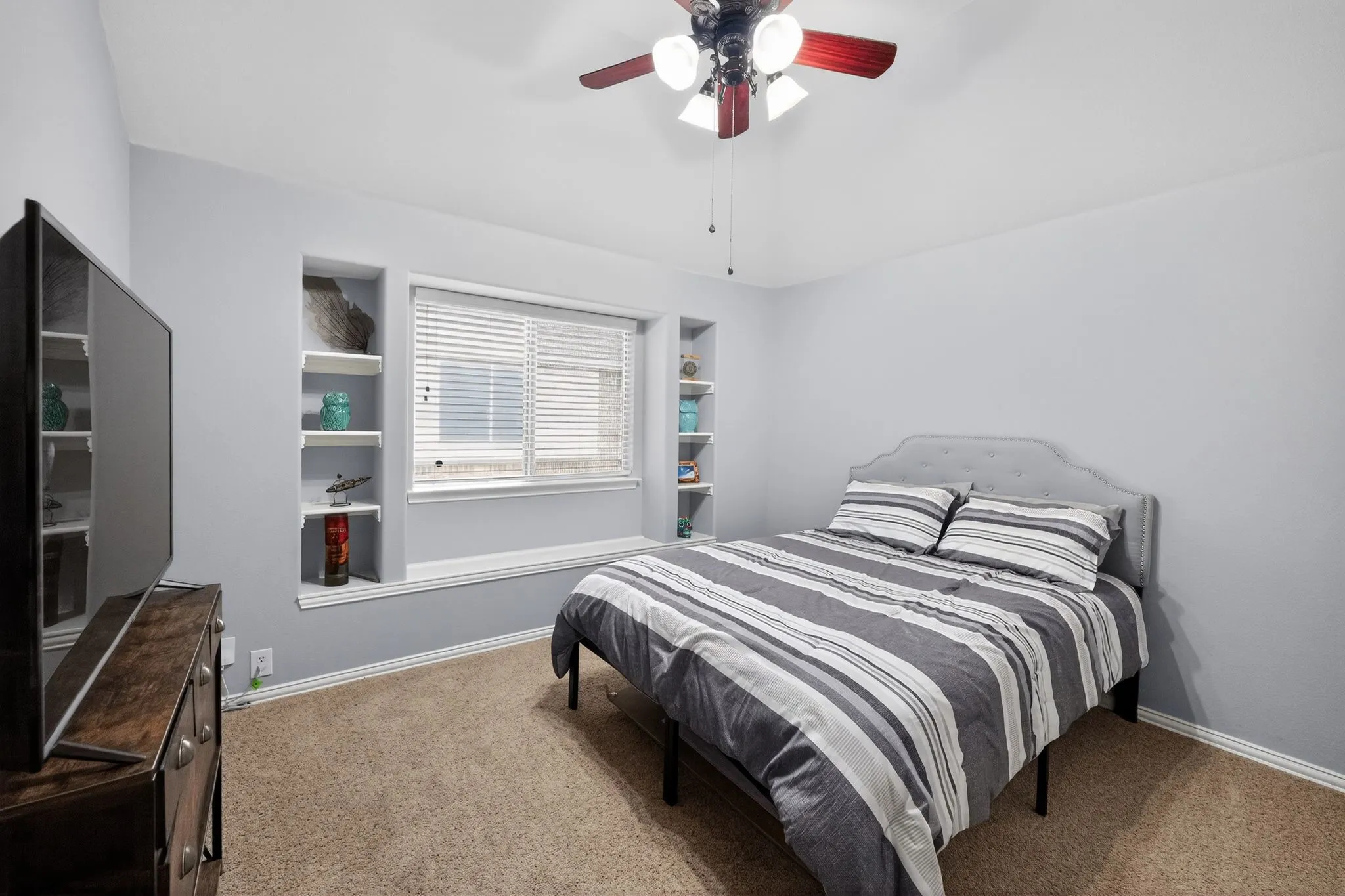 Upstairs - Bedroom #3 featuring recessed built-in shelving, a large window with blinds, and ceiling fan with integrated lighting