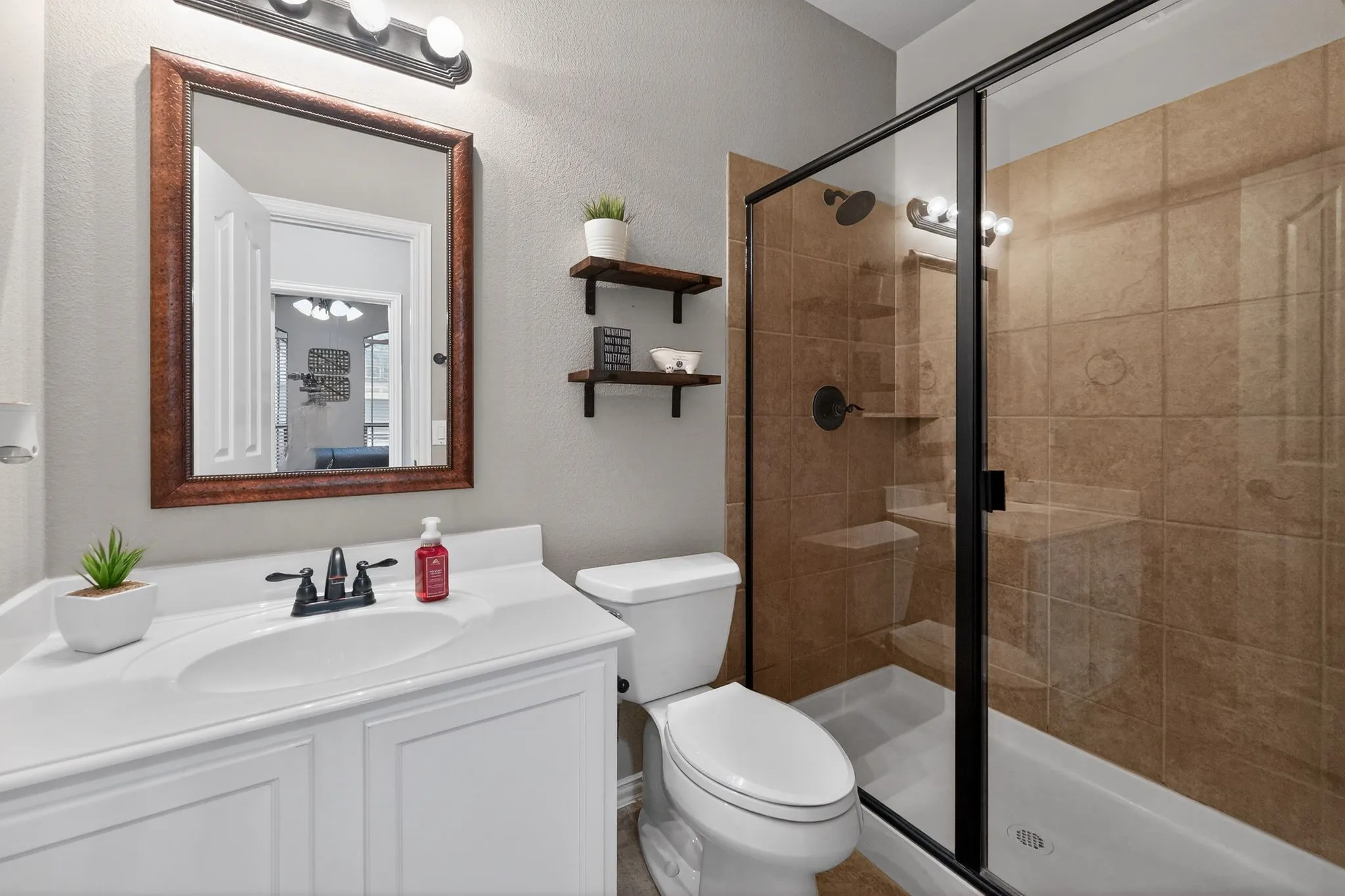 Downstairs Bathroom featuring a shower with glass enclosure and brown tile surround
