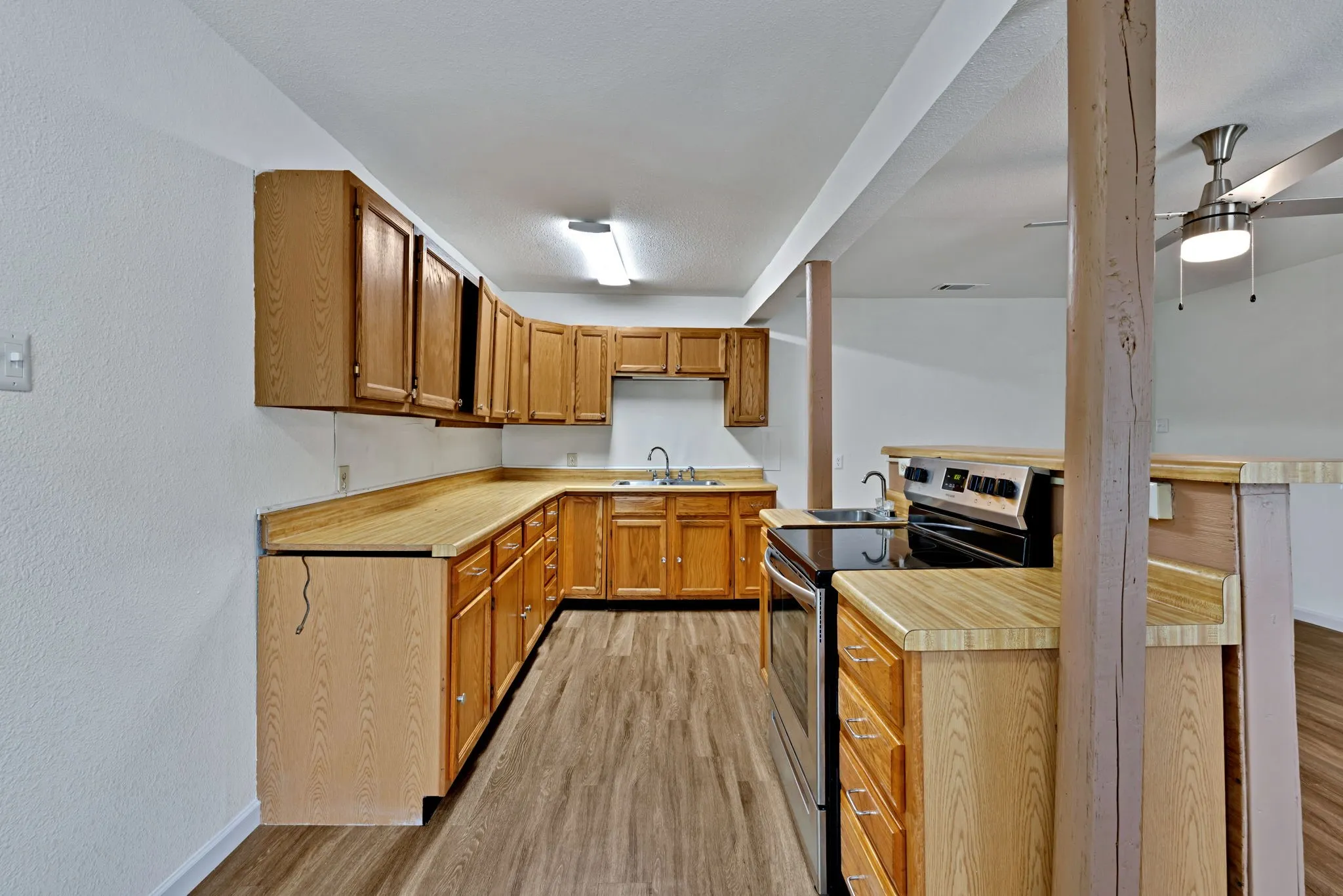 Kitchen featuring wood-finish cabinetry, laminate countertops, and stainless steel sink