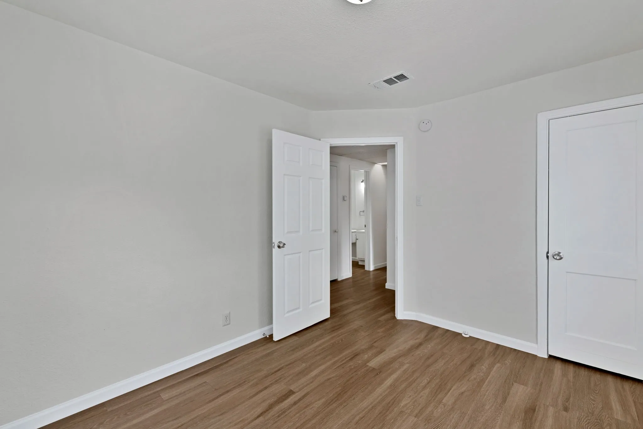 Room featuring wood-finish flooring and neutral wall tones