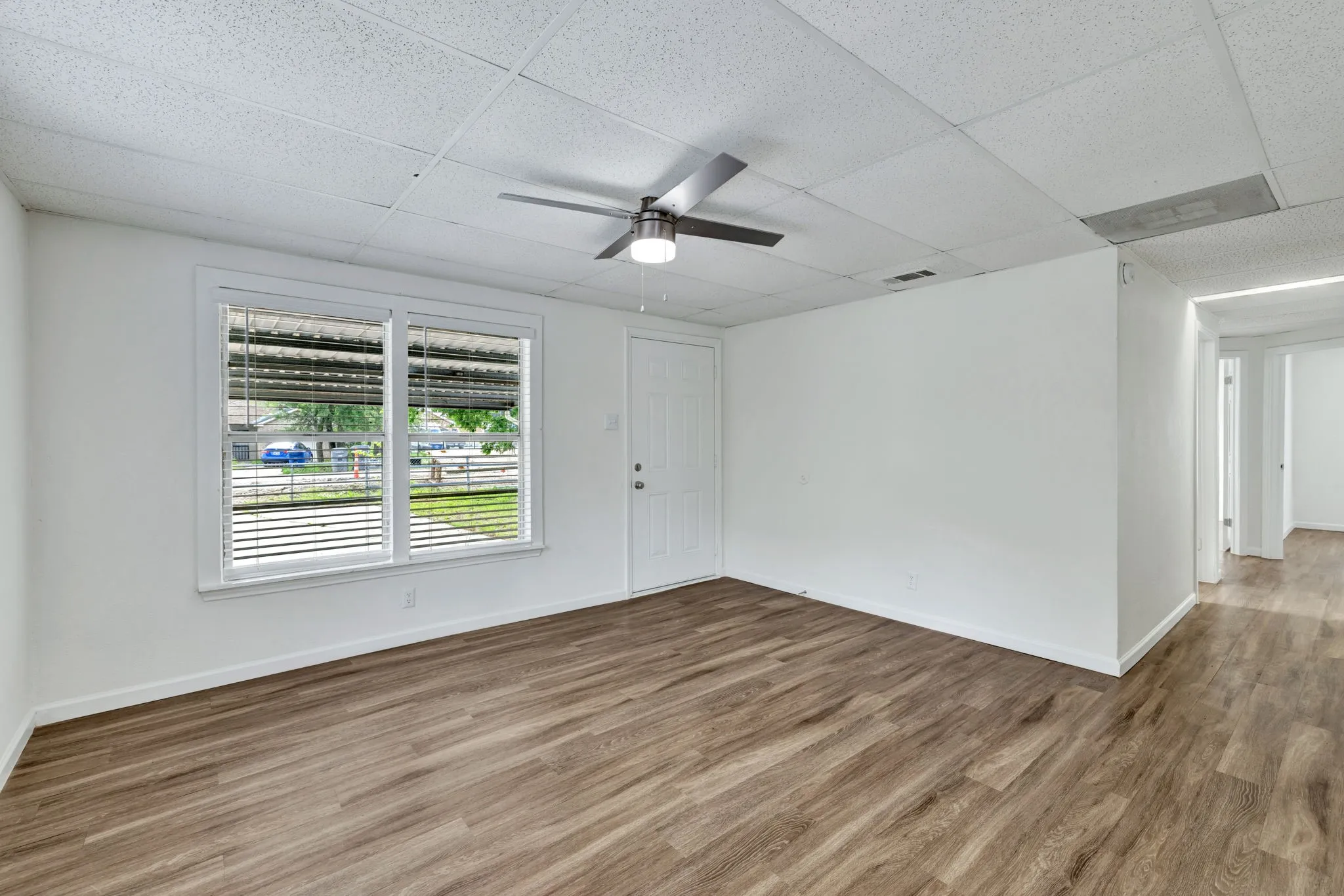 Bright interior space featuring wood-finish flooring, white walls, and a drop ceiling with recessed​​‌​​​​‌​​‌‌​‌‌​​​‌‌​‌​‌​‌​​​‌​​ lighting