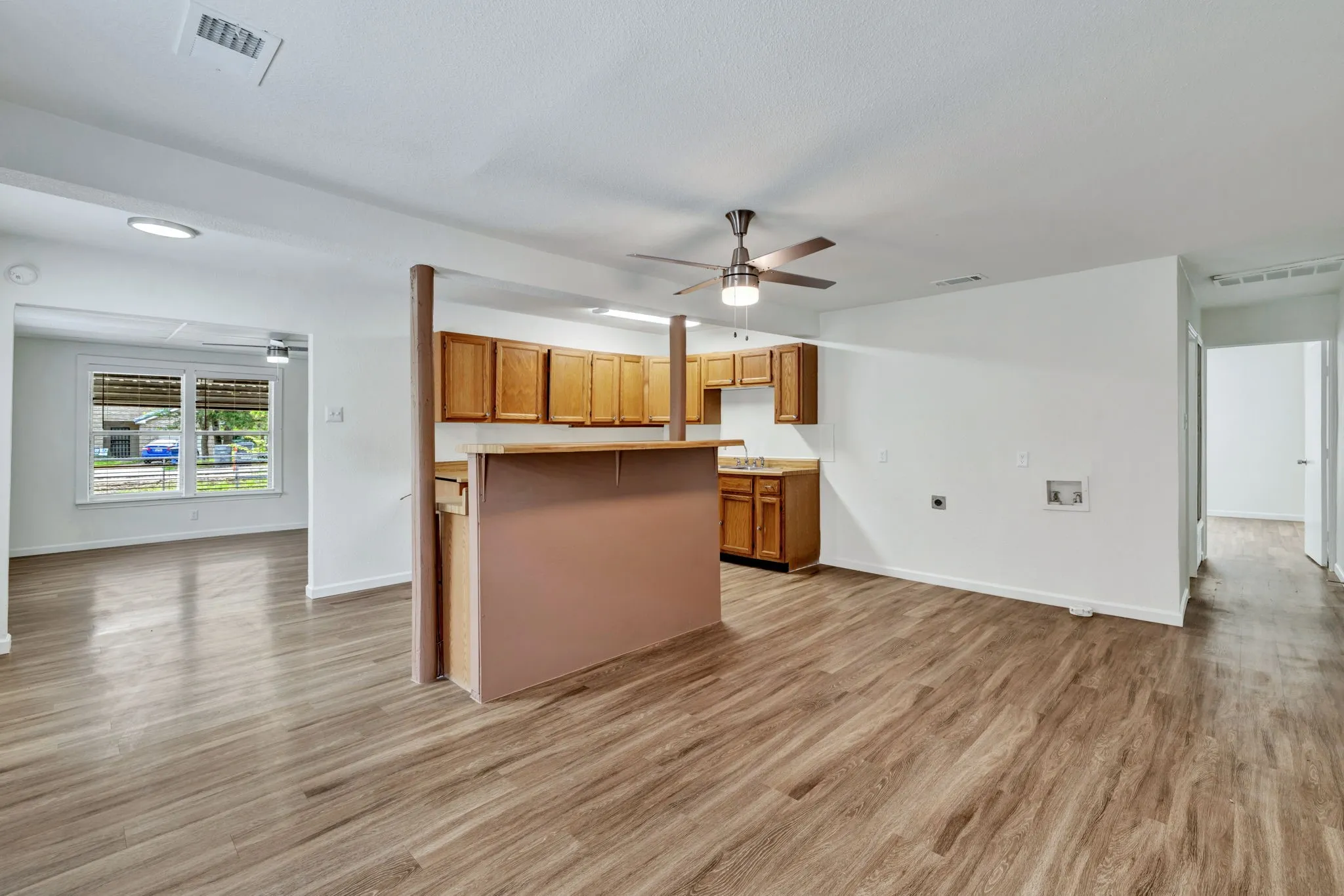 Open-concept living area featuring wood-finish flooring, recessed lighting, and a ceiling fan