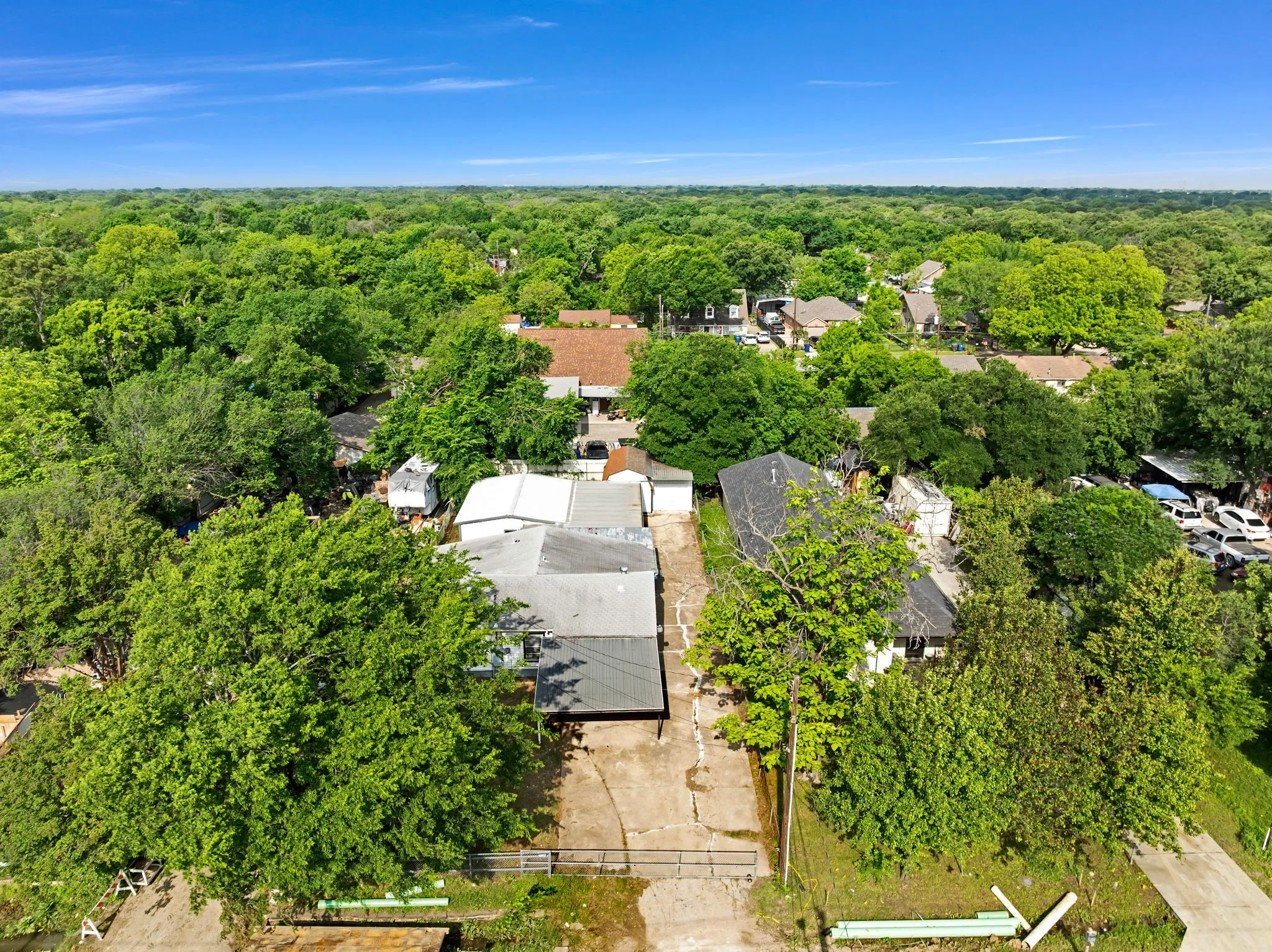 Aerial perspective showcasing a property surrounded by mature trees, with a dense tree canopy extending to the horizon