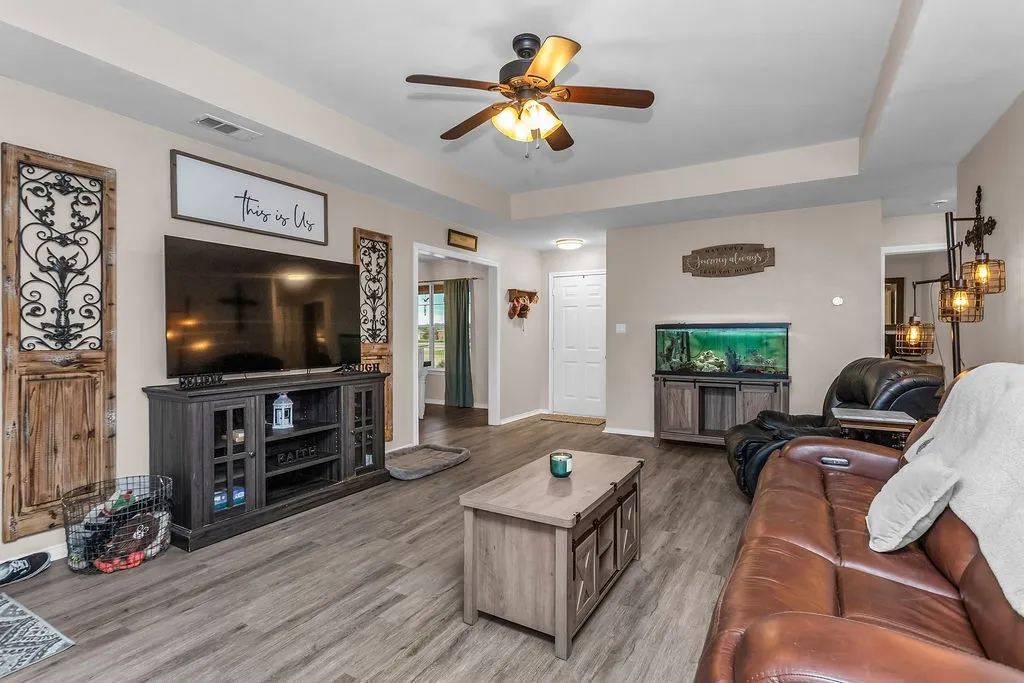Spacious living area featuring wood-finish flooring, recessed lighting, and a ceiling fan
