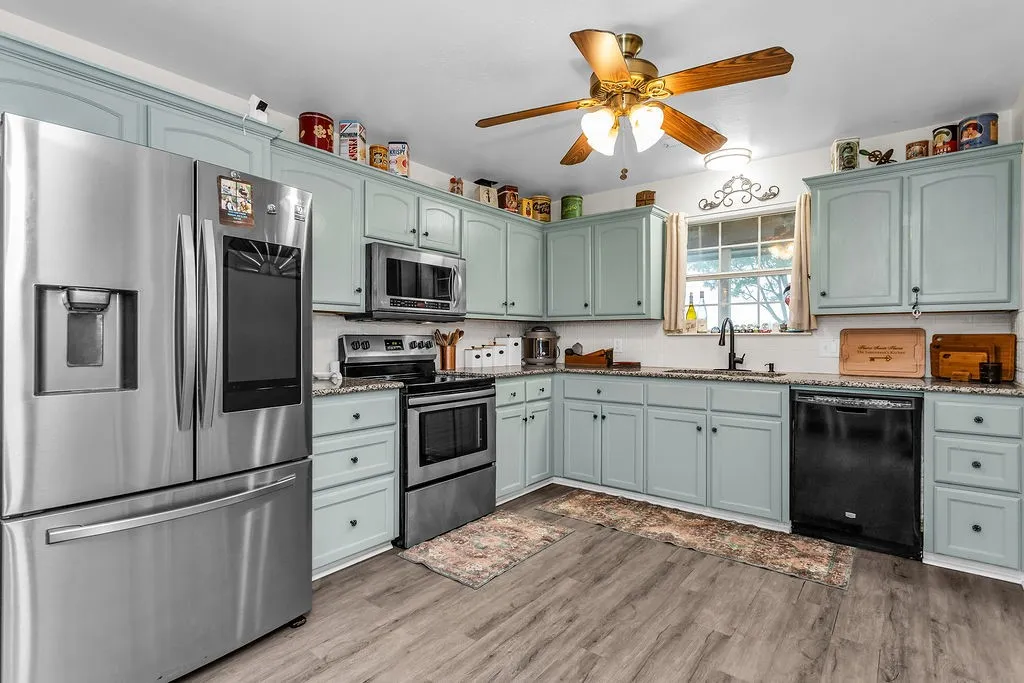 Kitchen featuring light blue cabinetry and wood-finish flooring