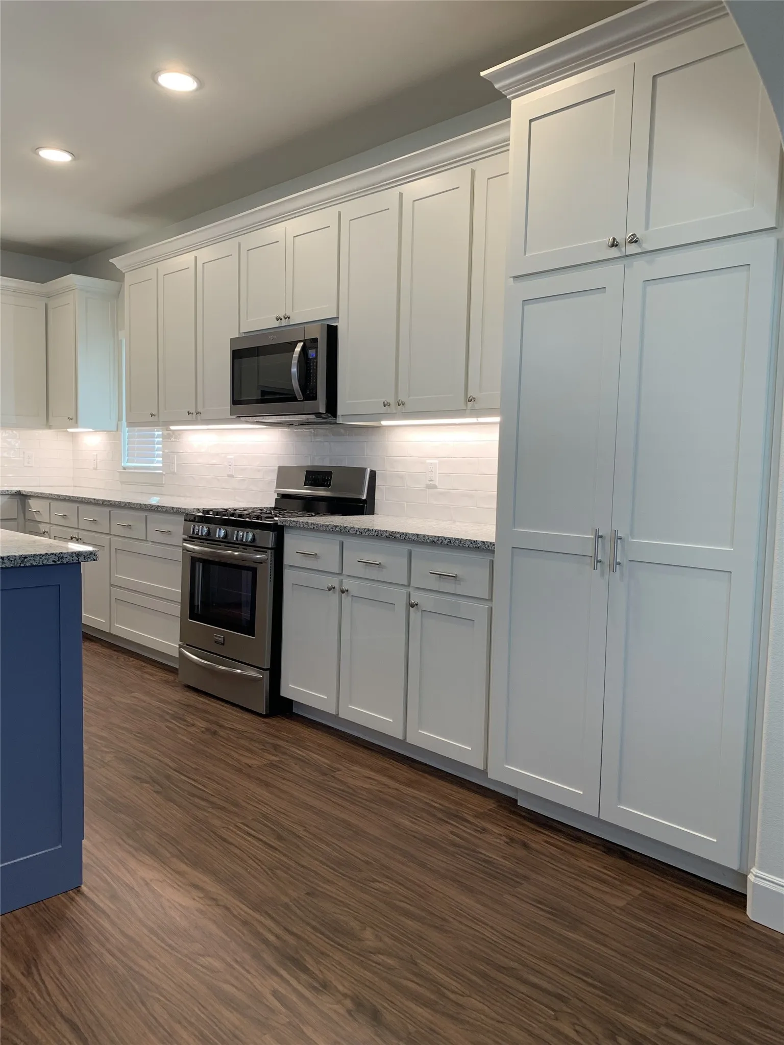 Kitchen featuring white shaker-style cabinetry, granite countertops, and a subway tile backsplash
