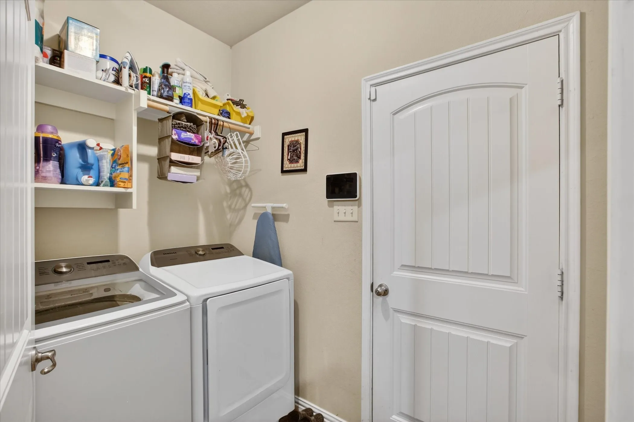 Dedicated utility space featuring light neutral walls and built-in shelving