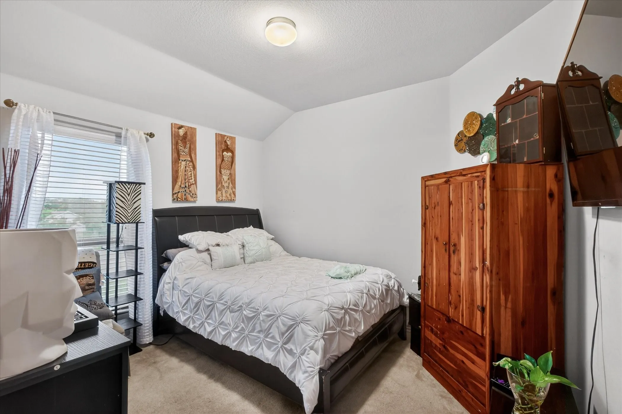 Spacious room featuring a window with blinds and sheer curtains, light-colored carpeting, a ceiling-mounted light fixture, and white wall finishes