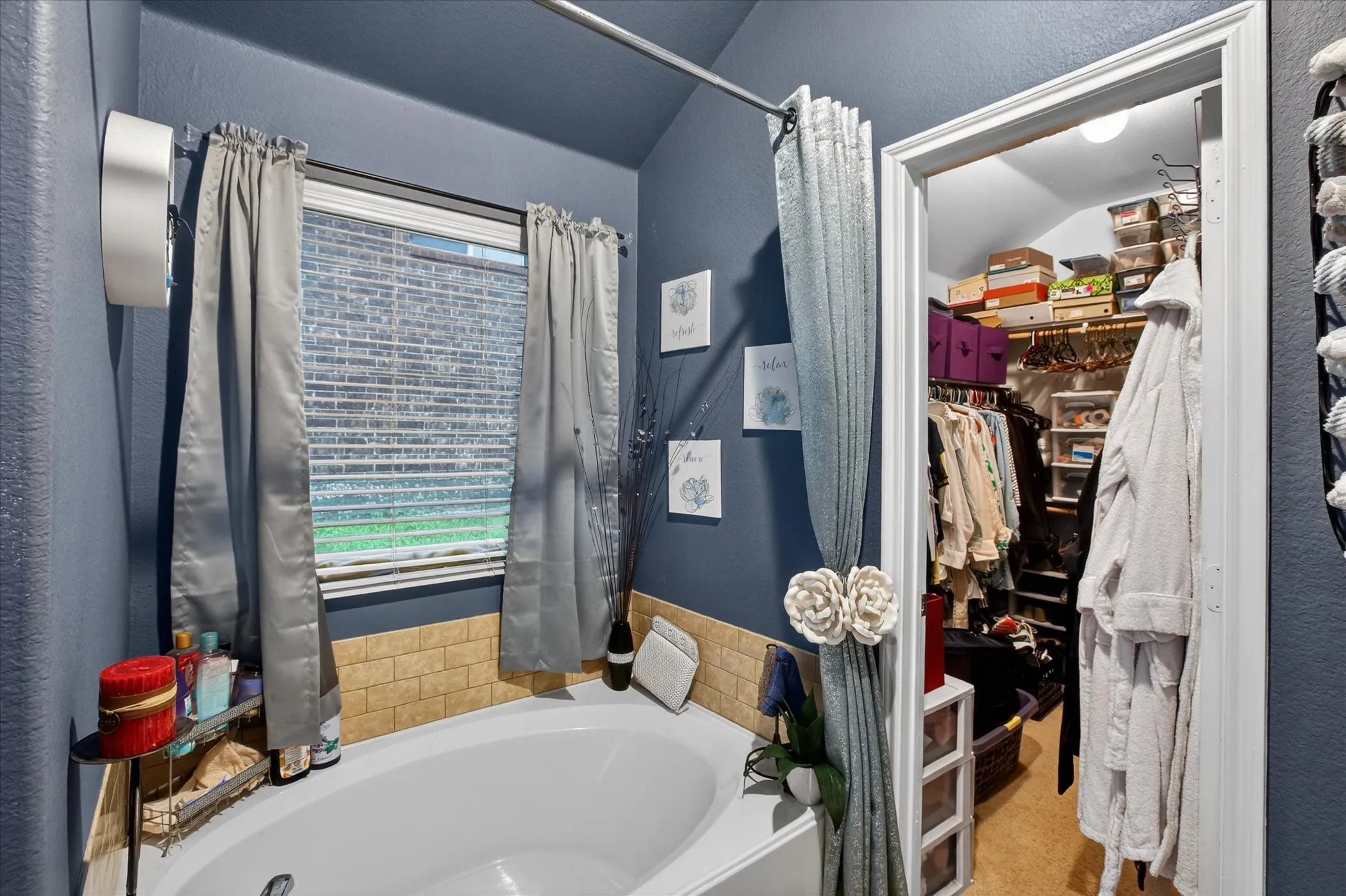 Soaking tub with tiled surround and window with blinds