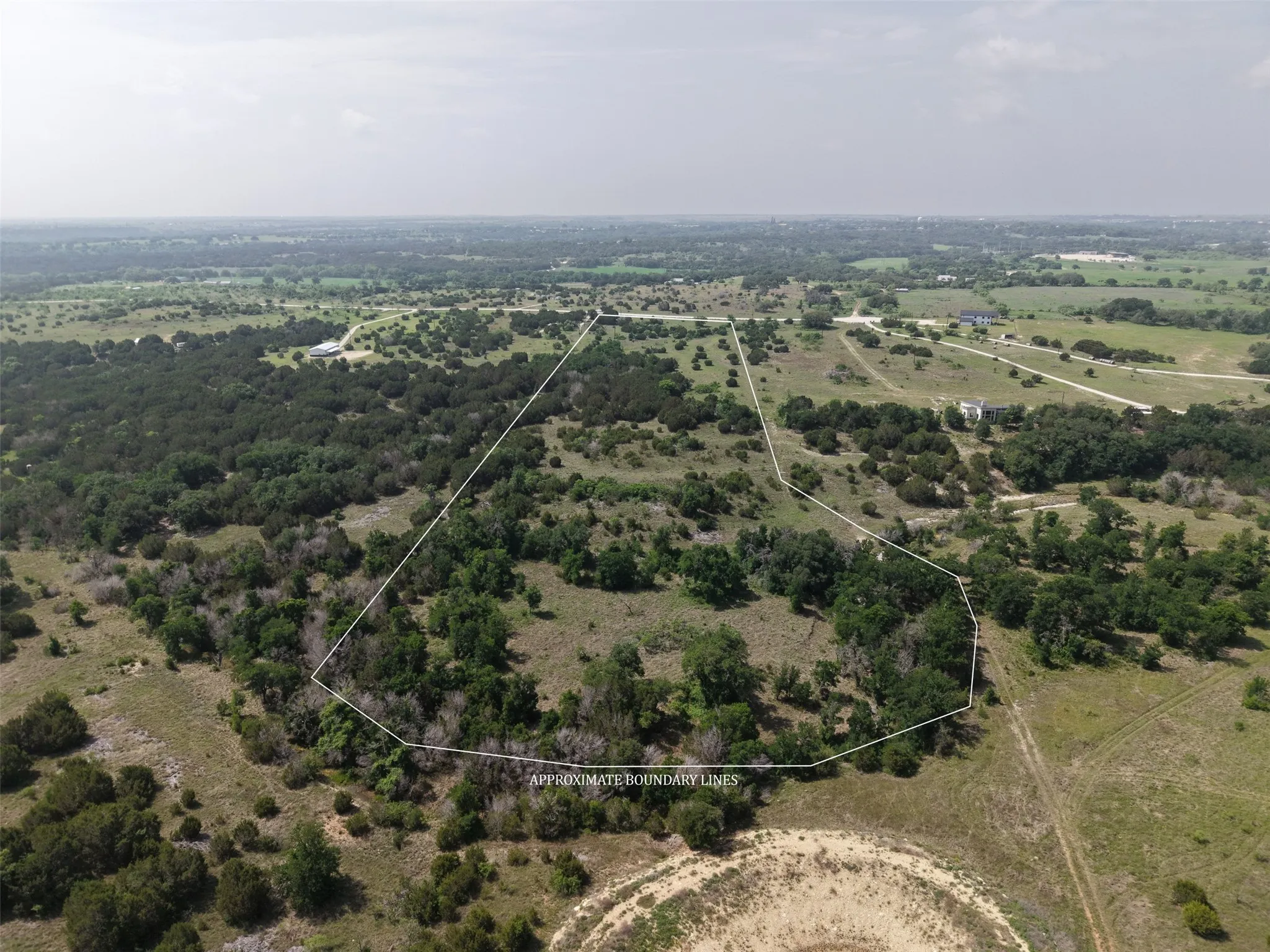 Expansive acreage featuring varied terrain, mature trees, and open fields, outlined by approximate boundary lines