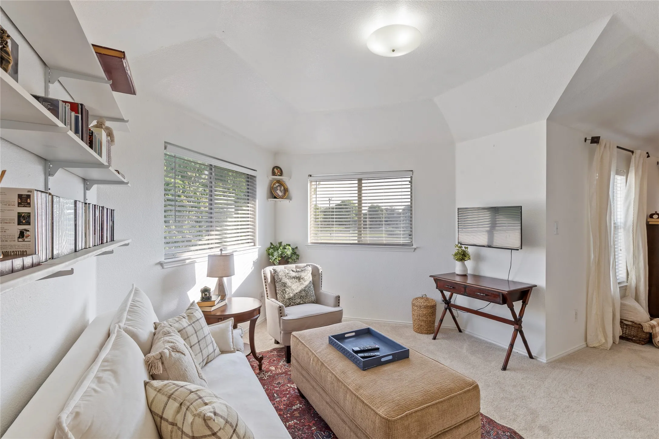 Spacious room with white walls, multiple windows with blinds, and white built-in shelving