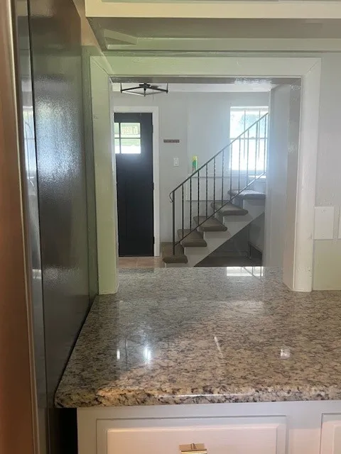 Kitchen passthrough featuring granite countertops