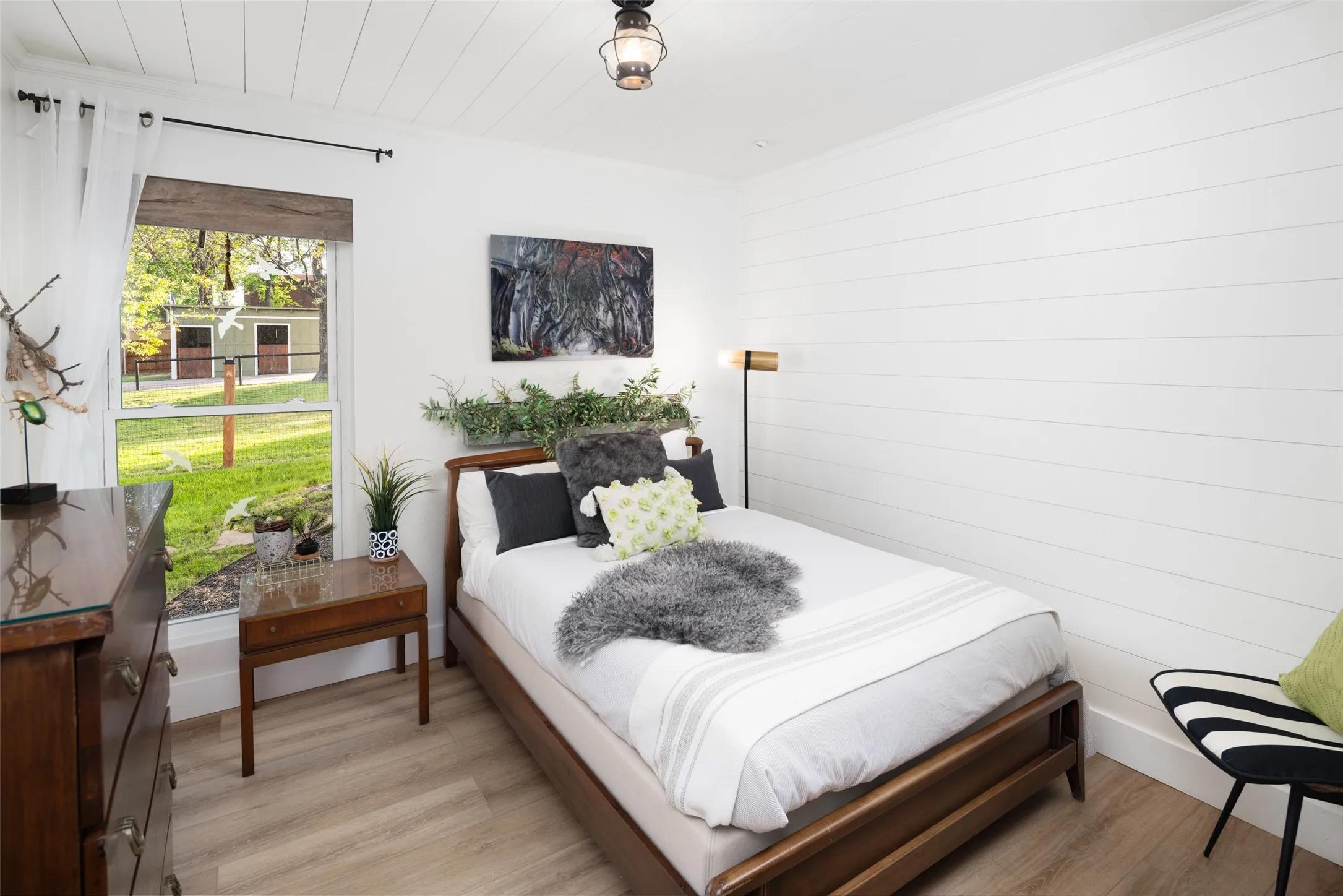 Third bedroom looks into the fenced yard to the horse stables and storage barn