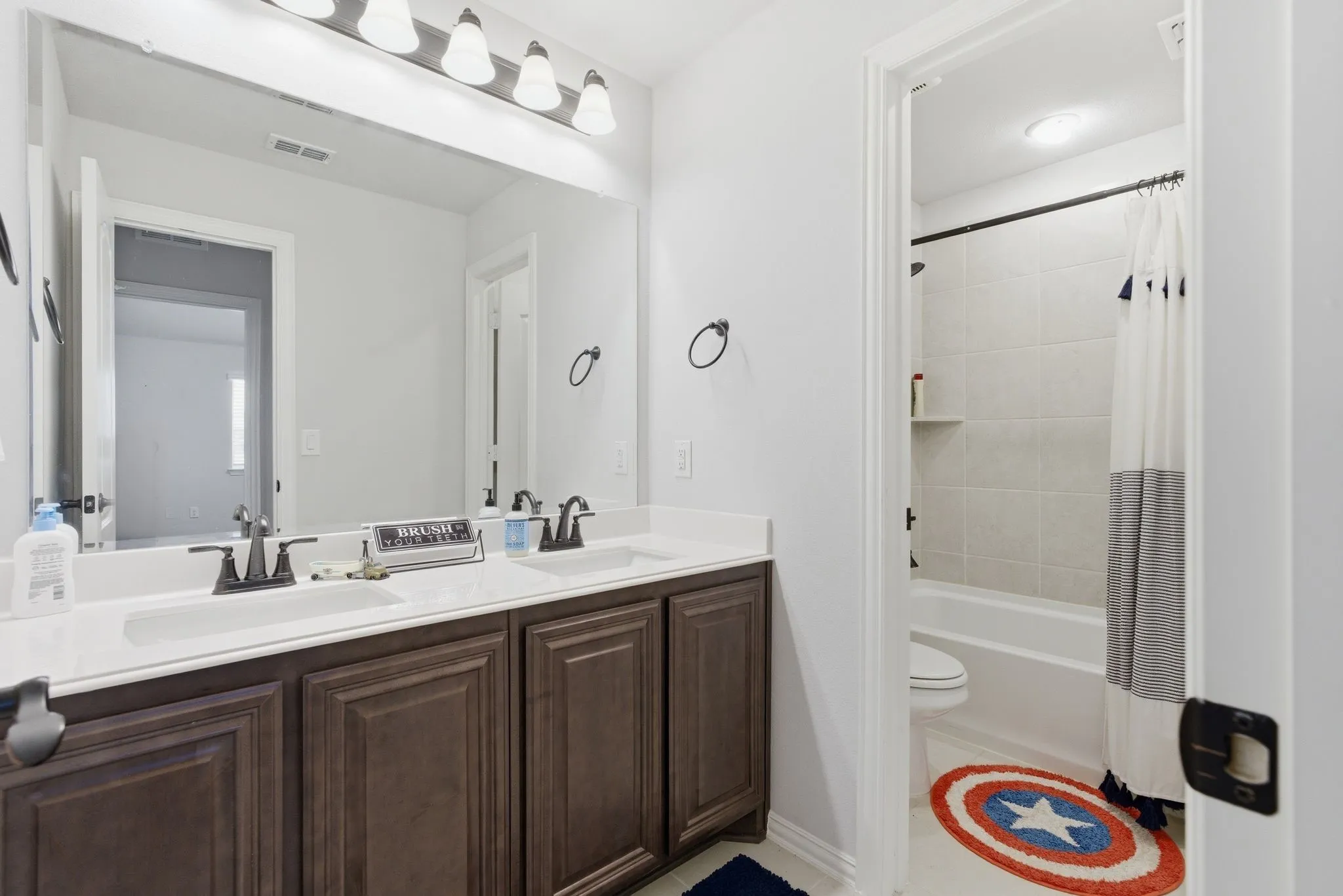 Upstairs hall bath with dual sinks and separation for the shower/tub and toilet area.