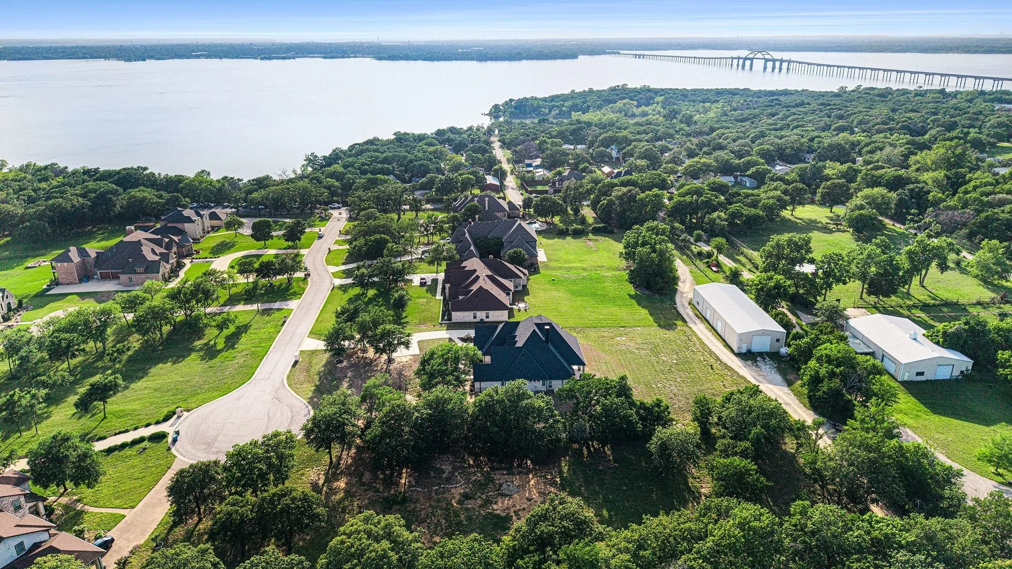 Aerial overview of the tree-lined community streets and custom homes surrounding Braewood Bay.