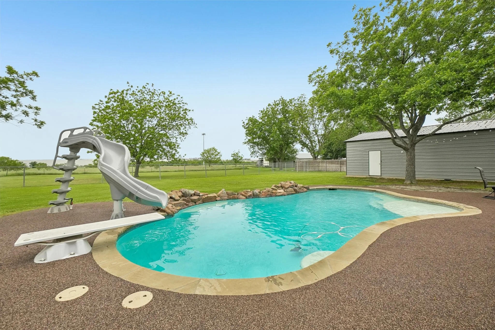 Resort-style pool with waterfall and water slide