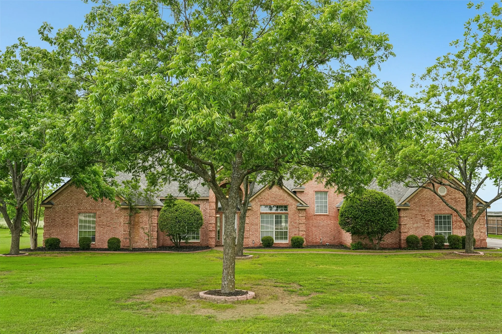 Front of the property with trees, located on a quiet cul-de-sac
