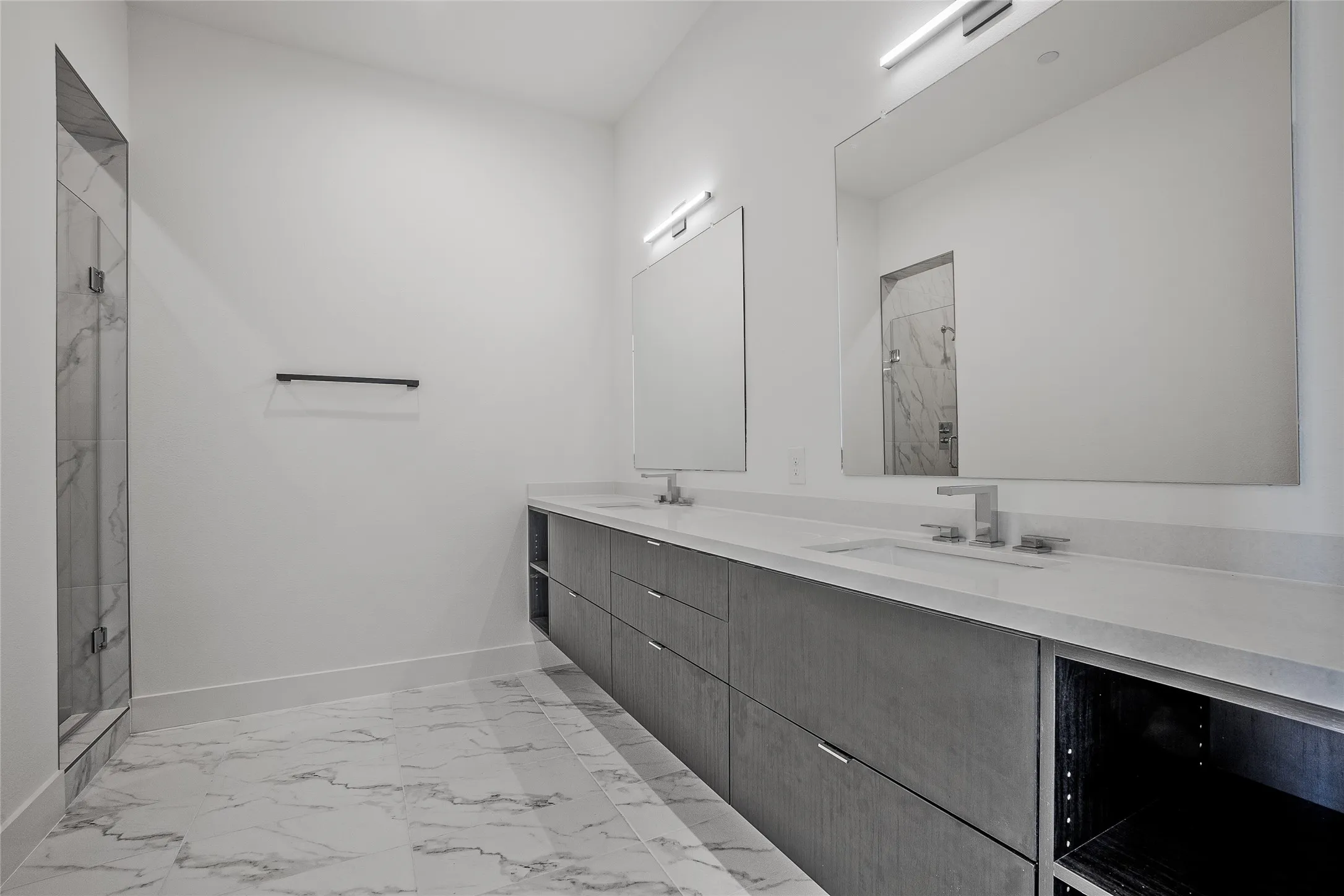 Spacious bathroom featuring a dual vanity with undermount sinks, stone countertops, and integrated storage