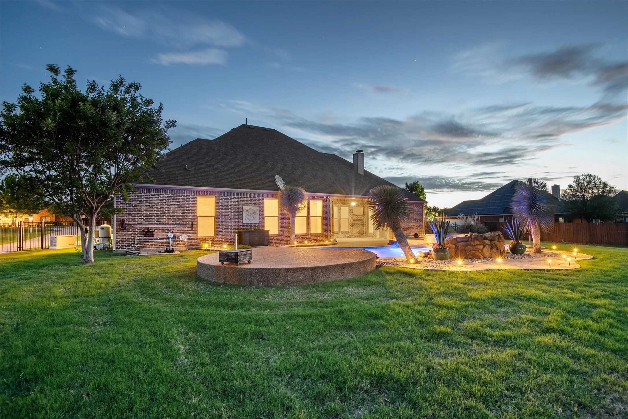 Expansive backyard featuring an in-ground swimming pool, and dedicated landscaping with a rock waterfall feature