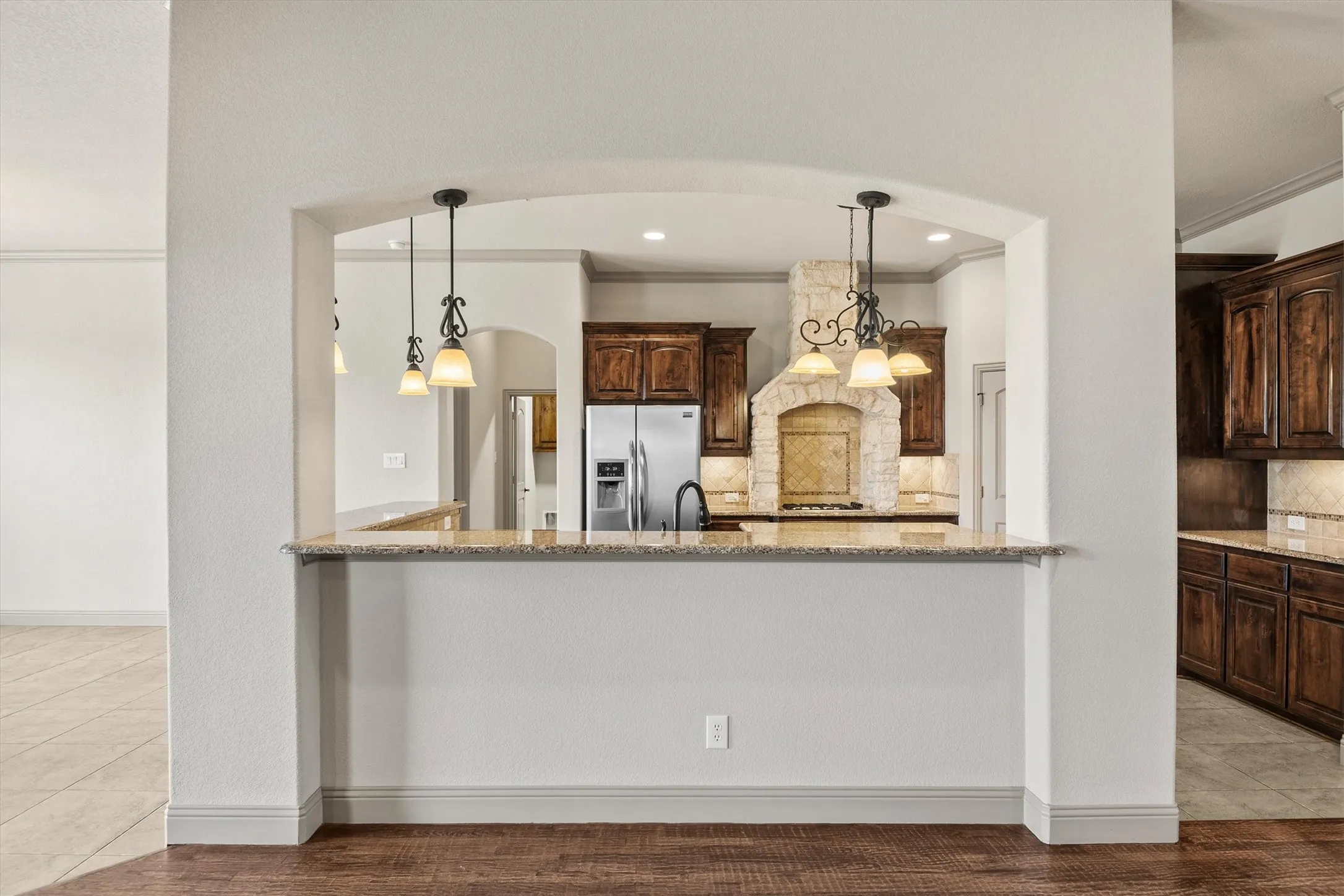 Kitchen pass-through with granite countertops and integrated bar seating