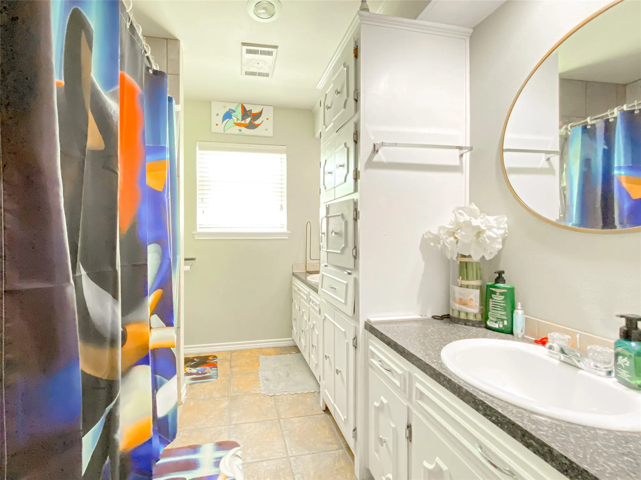 Bathroom with a single vanity, undermount sink, and dark speckled countertop