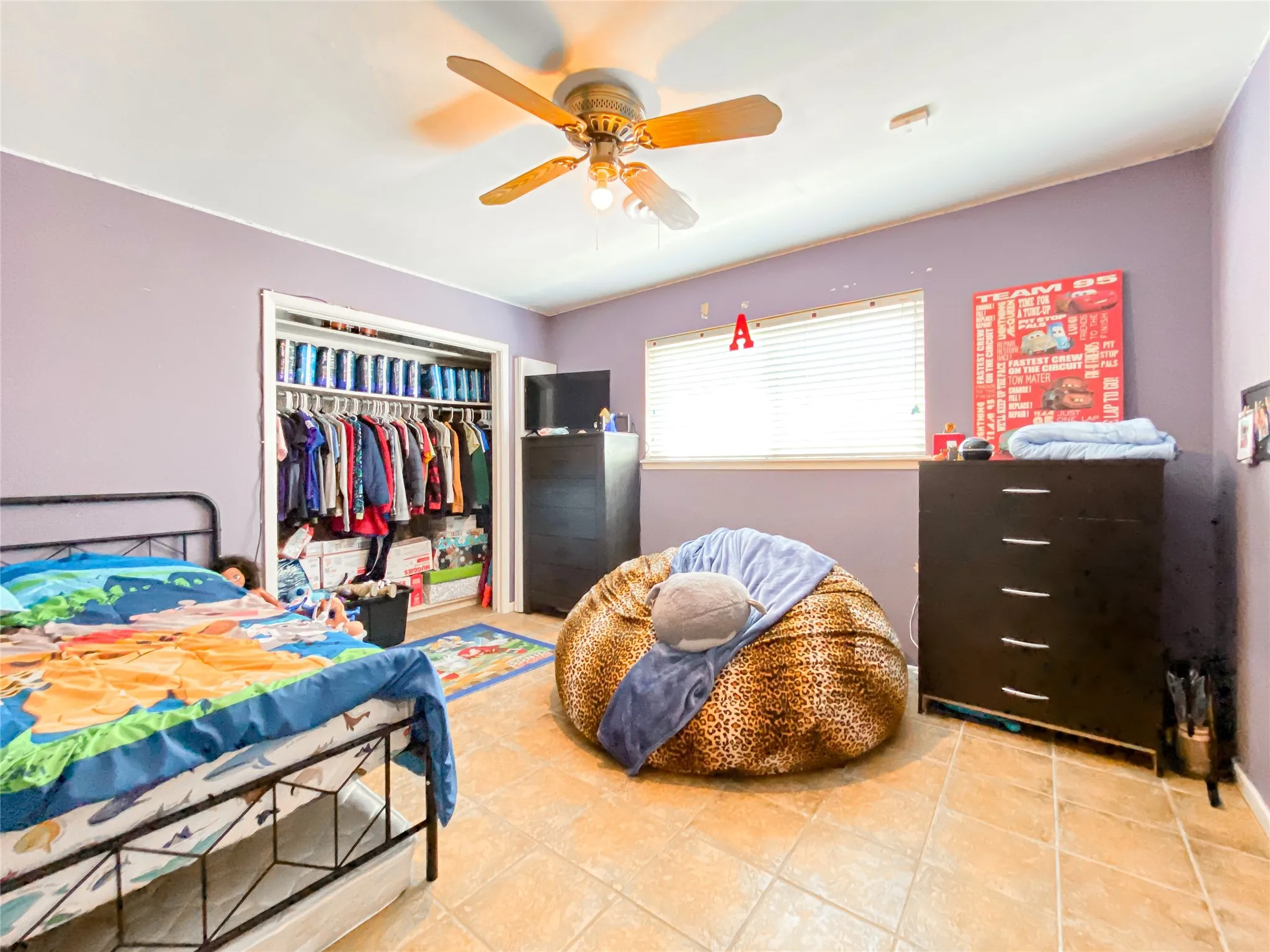 Bedroom featuring tile flooring, a ceiling fan, and a window with blinds