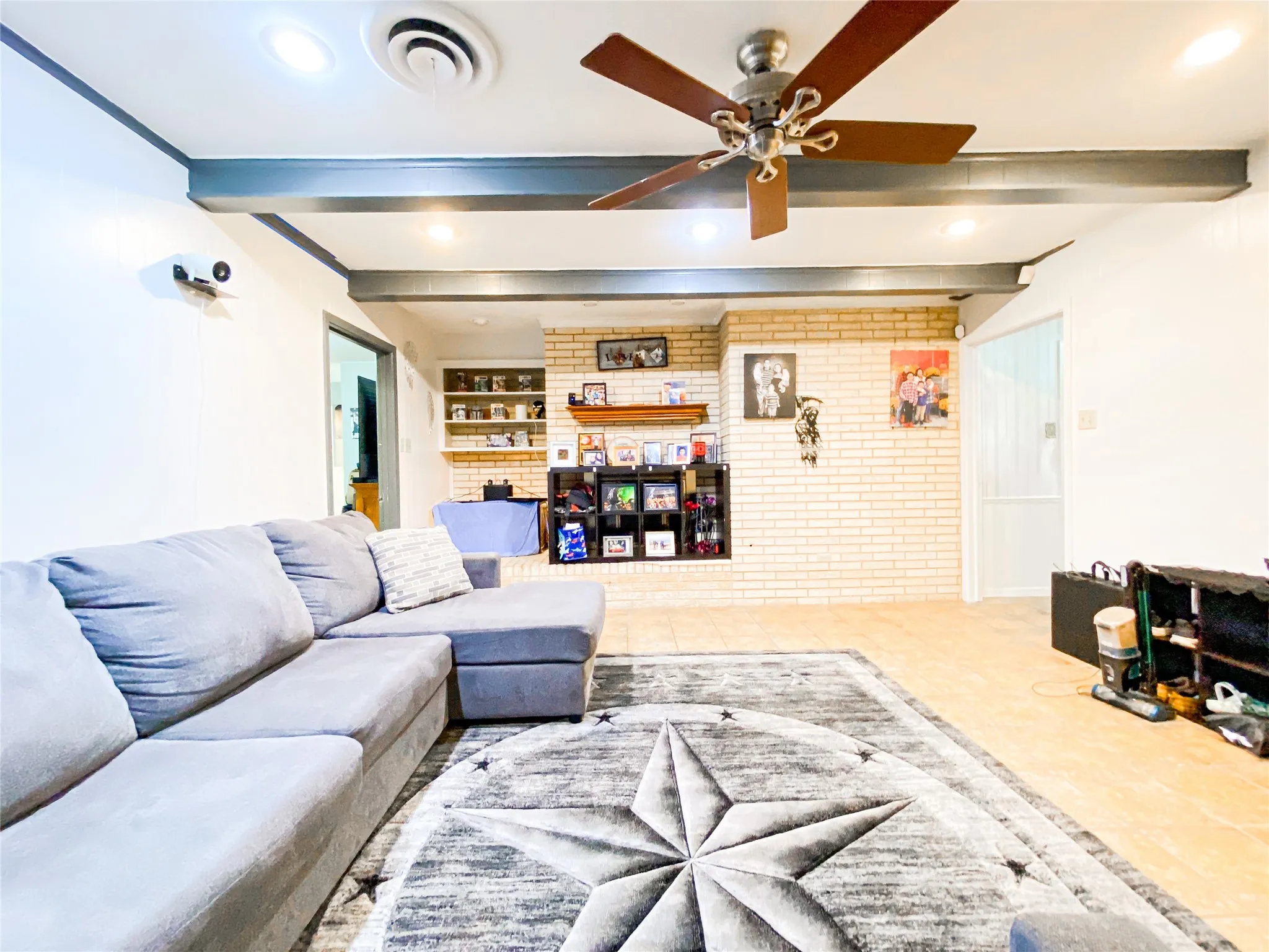 Spacious living area featuring exposed ceiling beams and recessed lighting