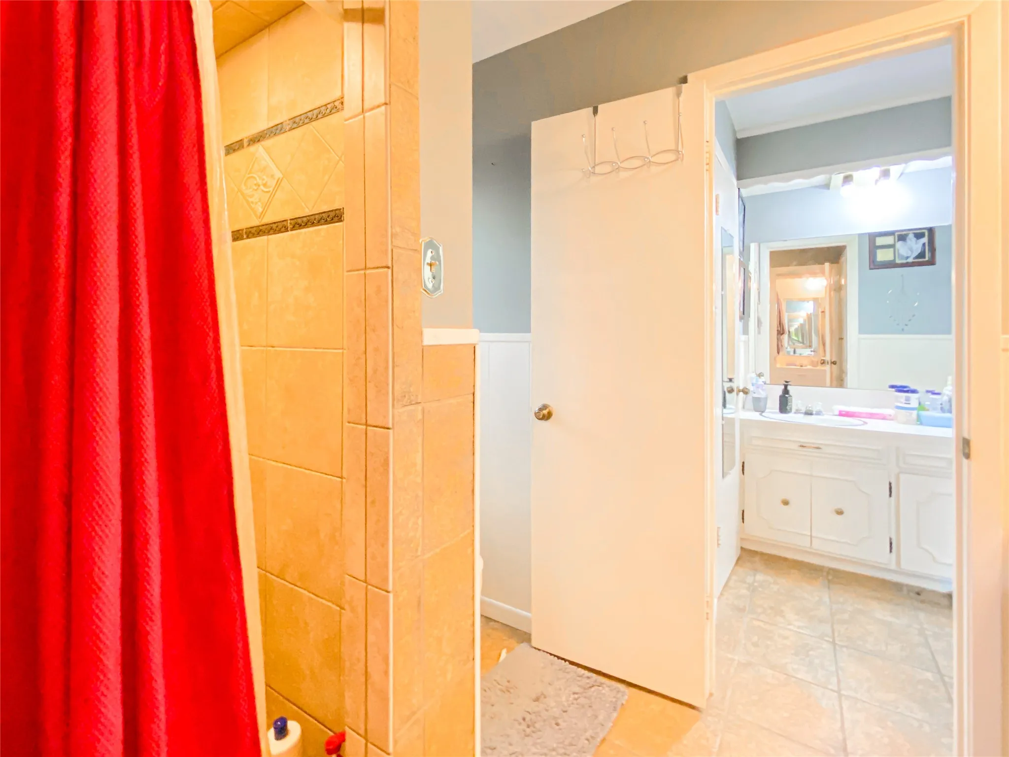 Shower enclosure with neutral-toned tiled walls, featuring decorative accent tiles