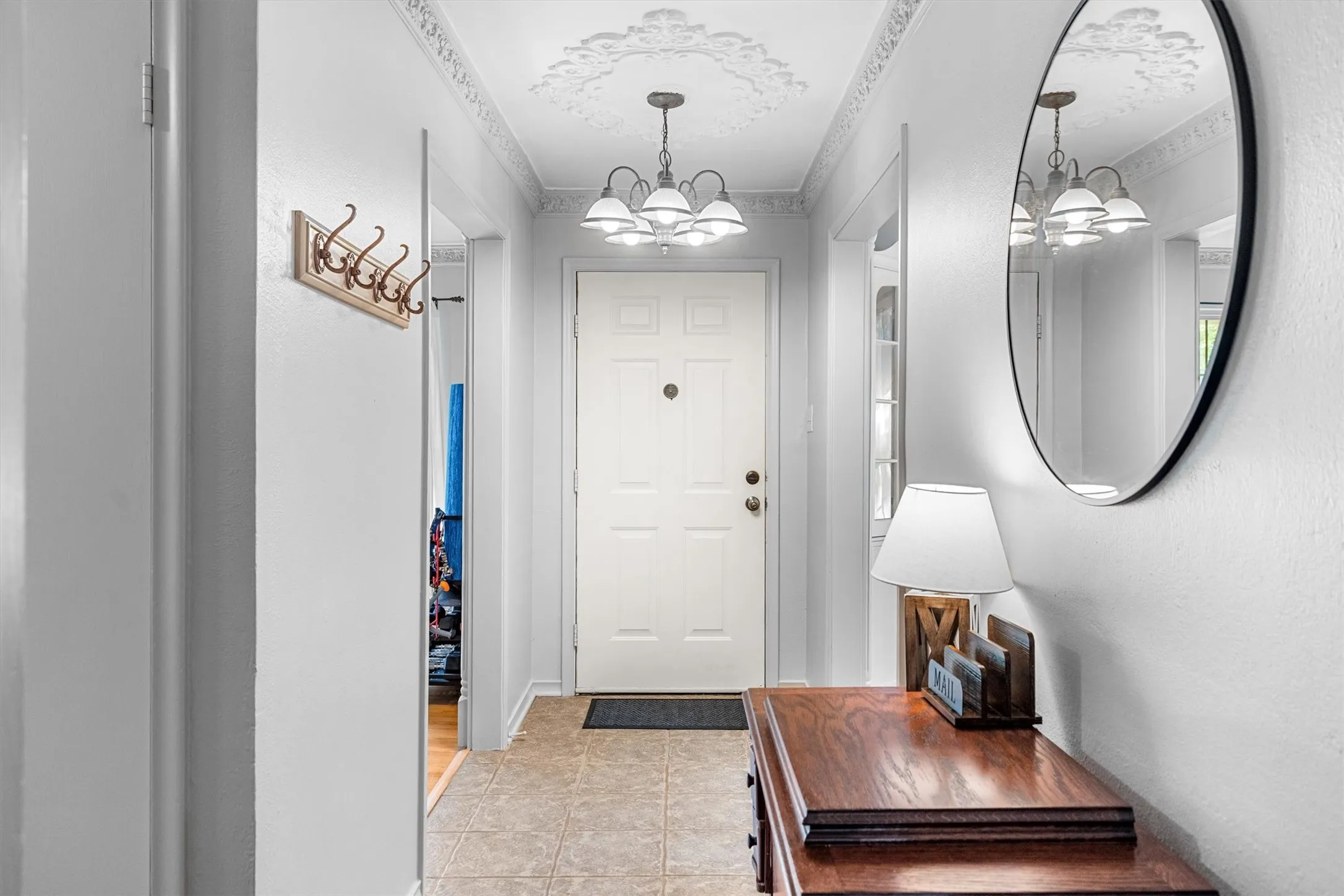 Entryway featuring tile flooring and a decorative ceiling medallion with an attached chandelier
