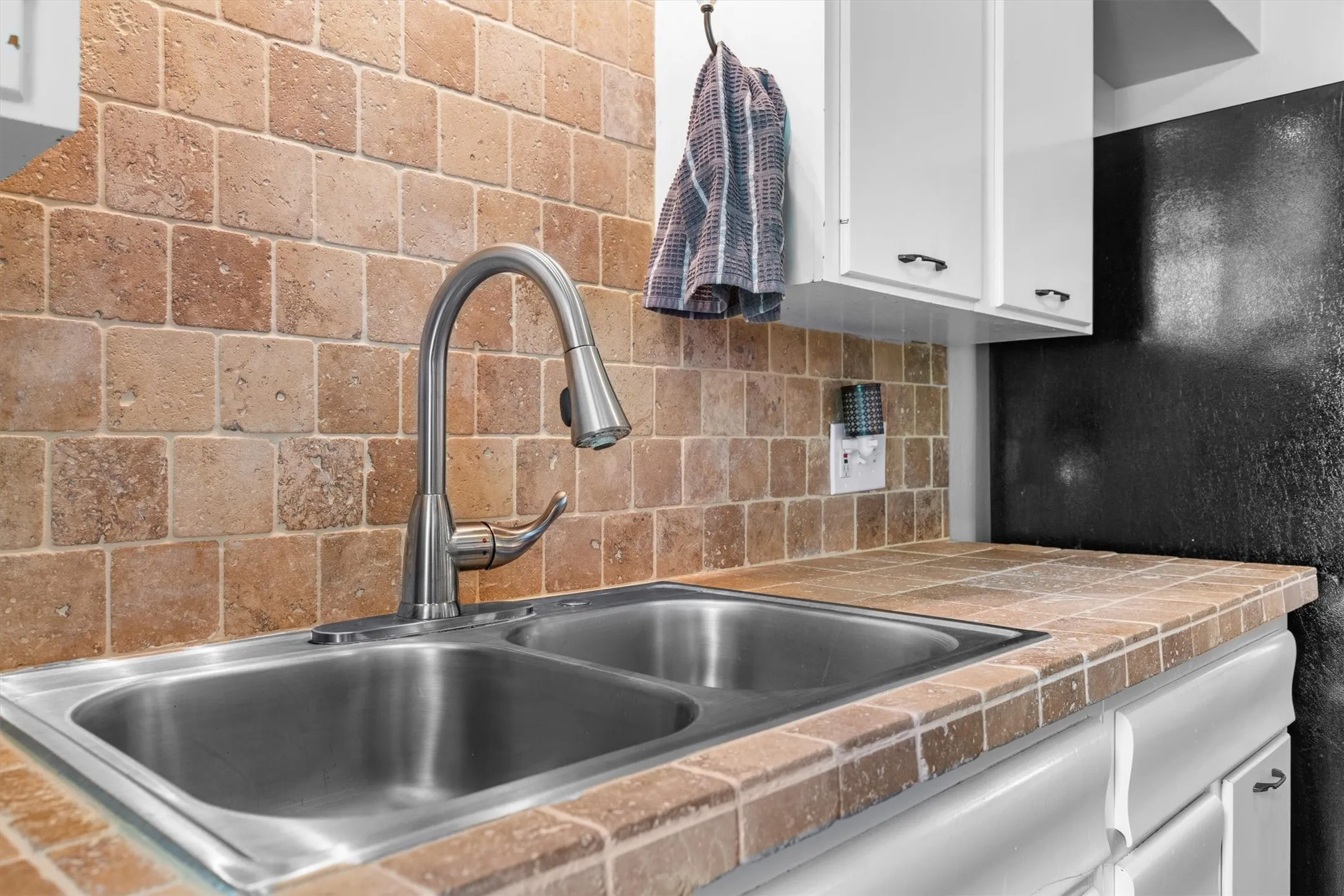 Kitchen sink featuring a dual basin, stainless steel construction, and a gooseneck faucet with a pull-down sprayer
