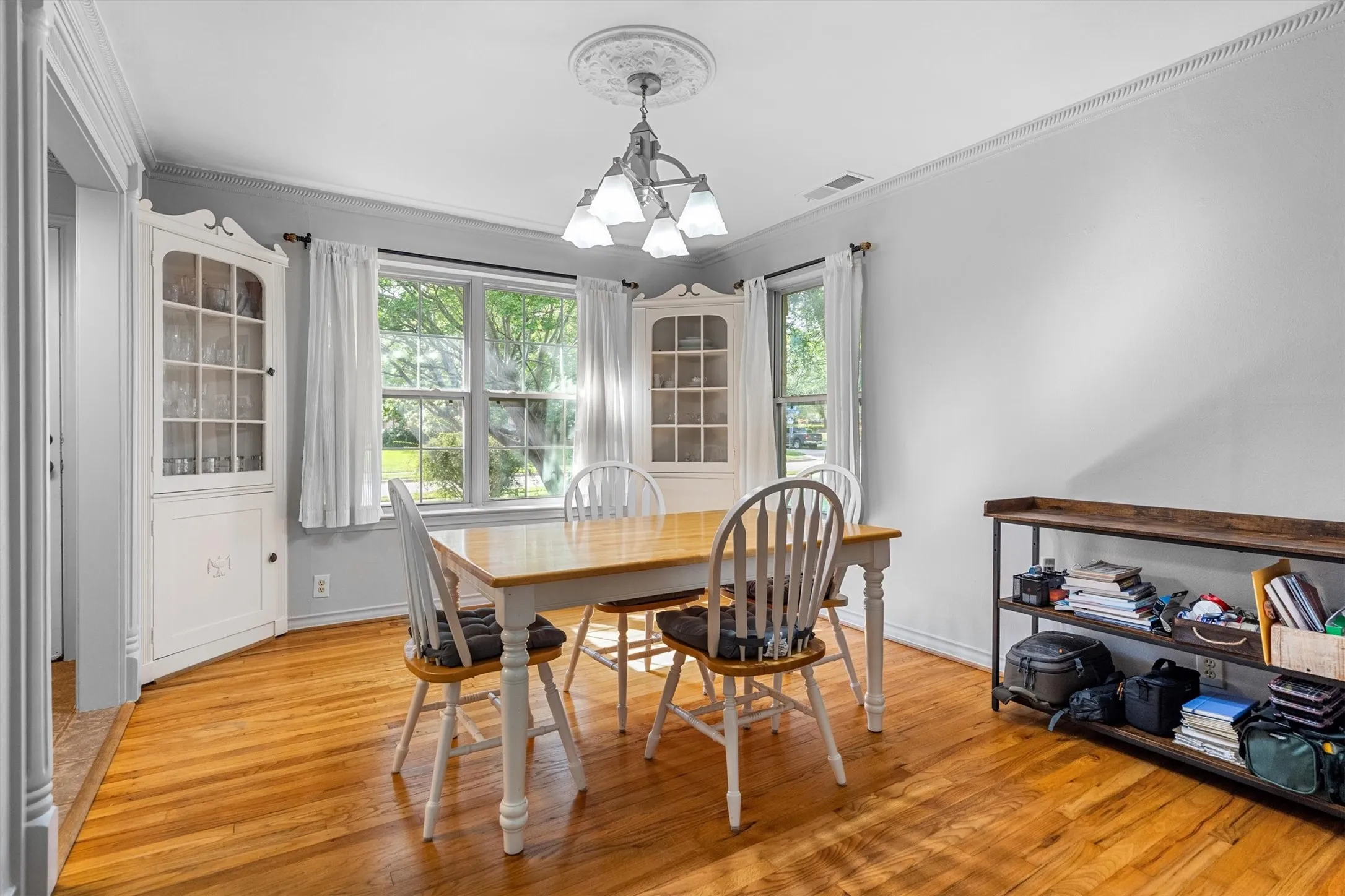 Bright interior space featuring wood-finish flooring, white walls, and crown molding
