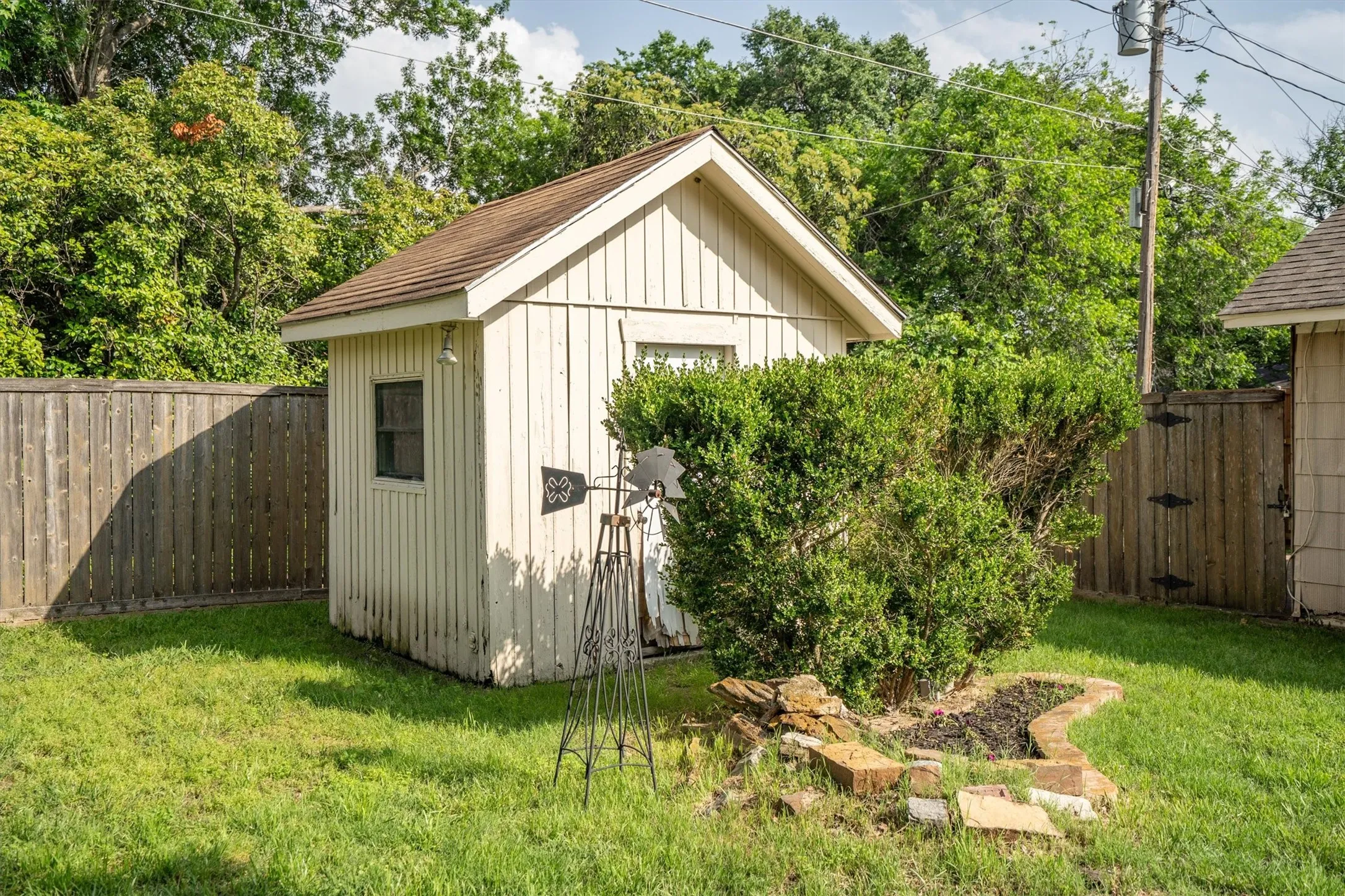 Backyard area featuring a detached storage shed with vertical siding and a shingled roof