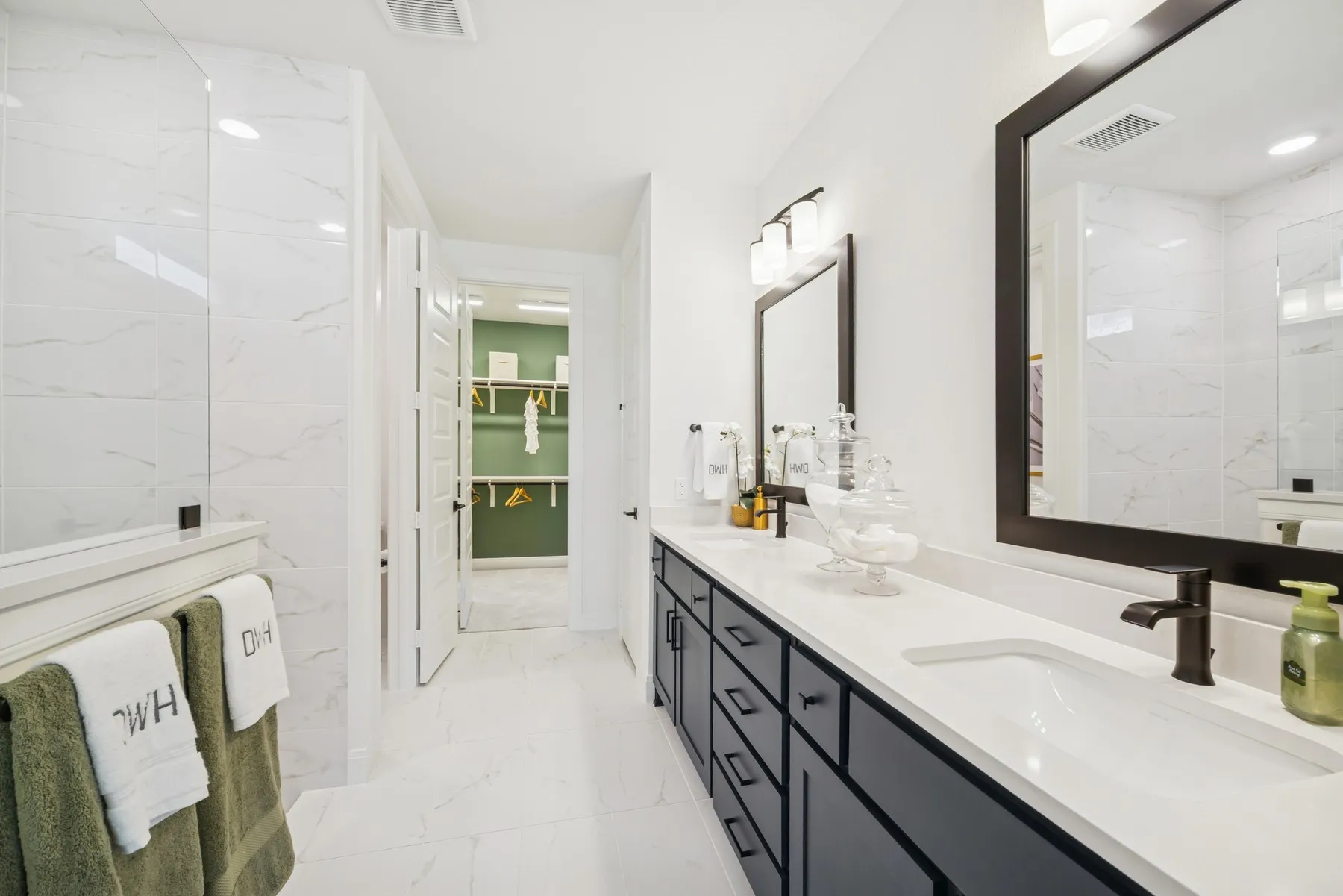Spacious bathroom featuring a dual vanity with dark cabinetry, integrated sinks, and bronze-finish faucets