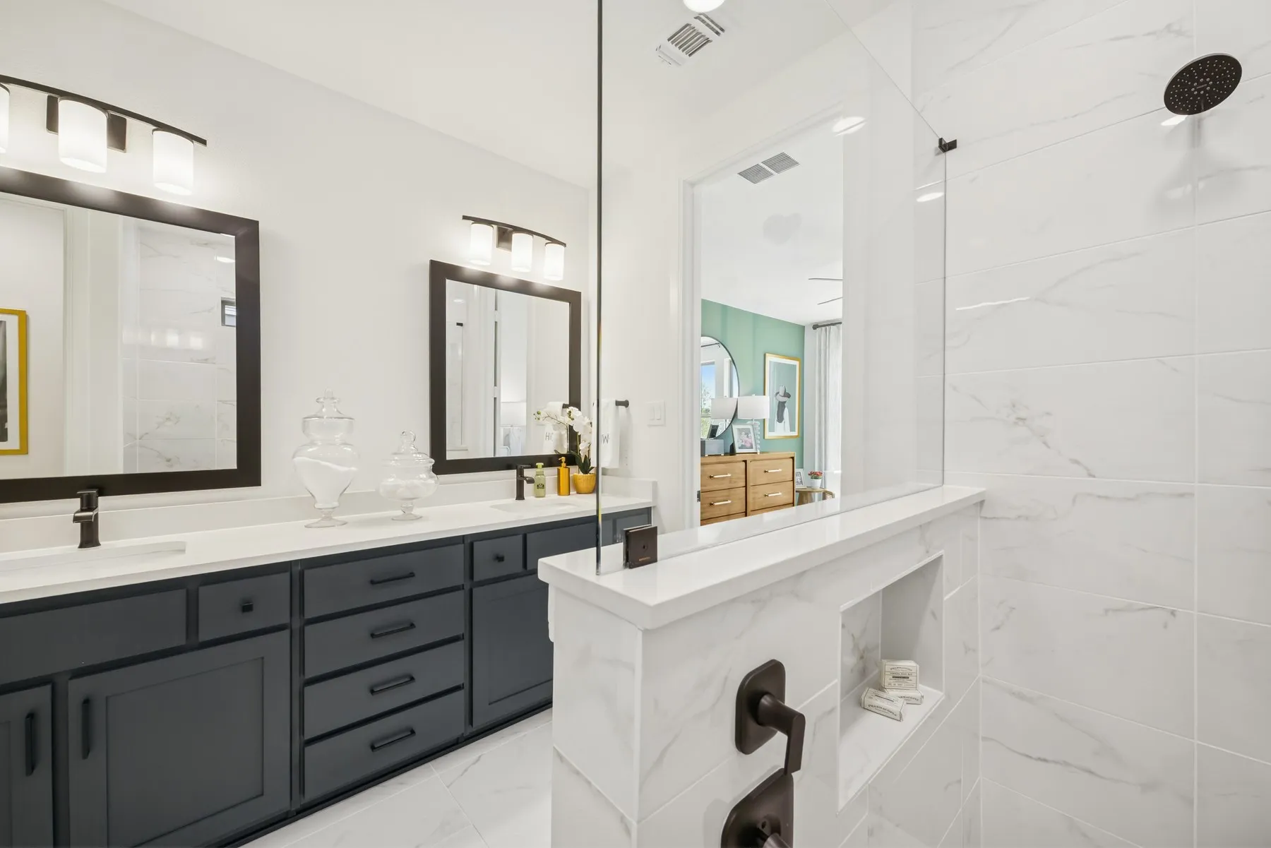 Dual vanity with dark cabinetry, white countertops, and framed mirrors