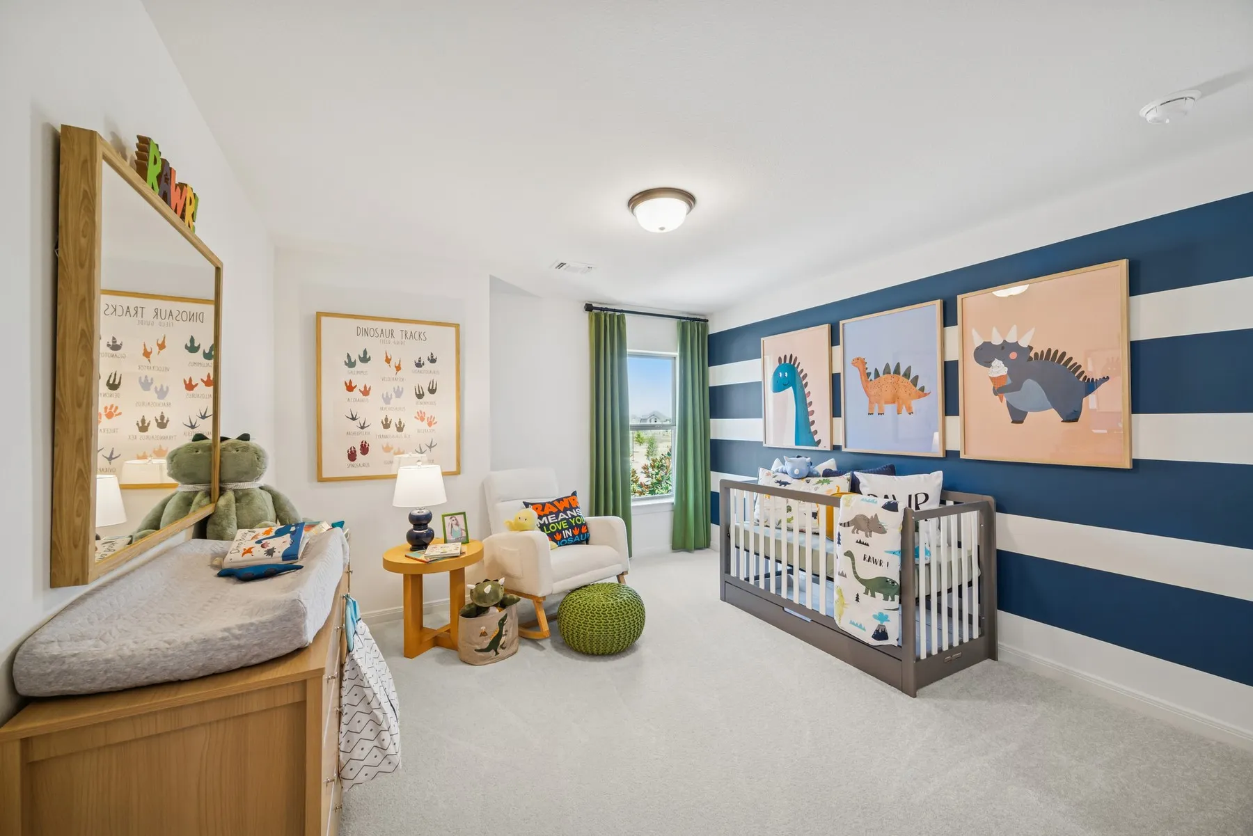 Bright room featuring a blue and white striped accent wall, a window with green drapes, and light-colored carpeting