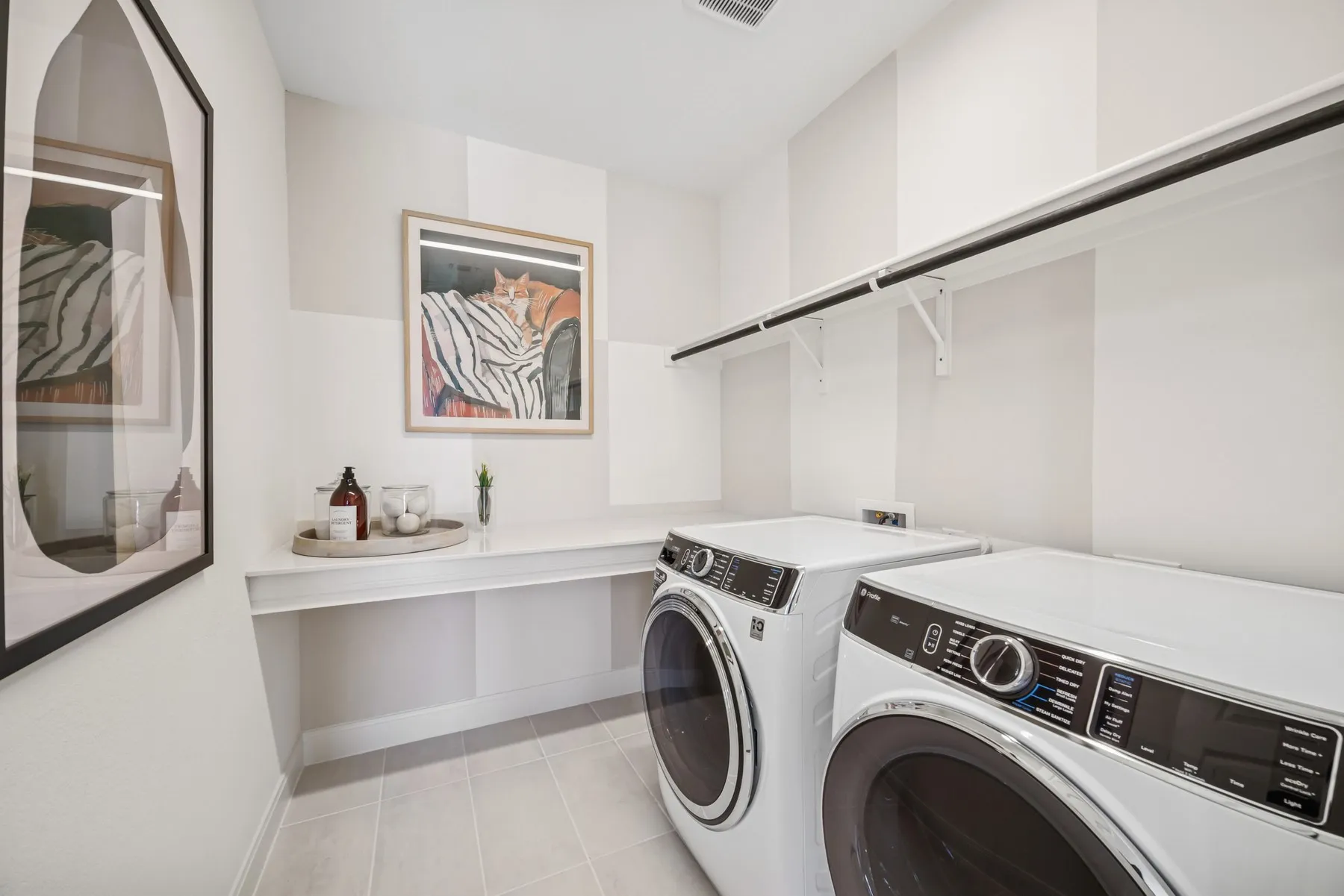 Laundry room with tile flooring, a built-in counter, and upper shelving